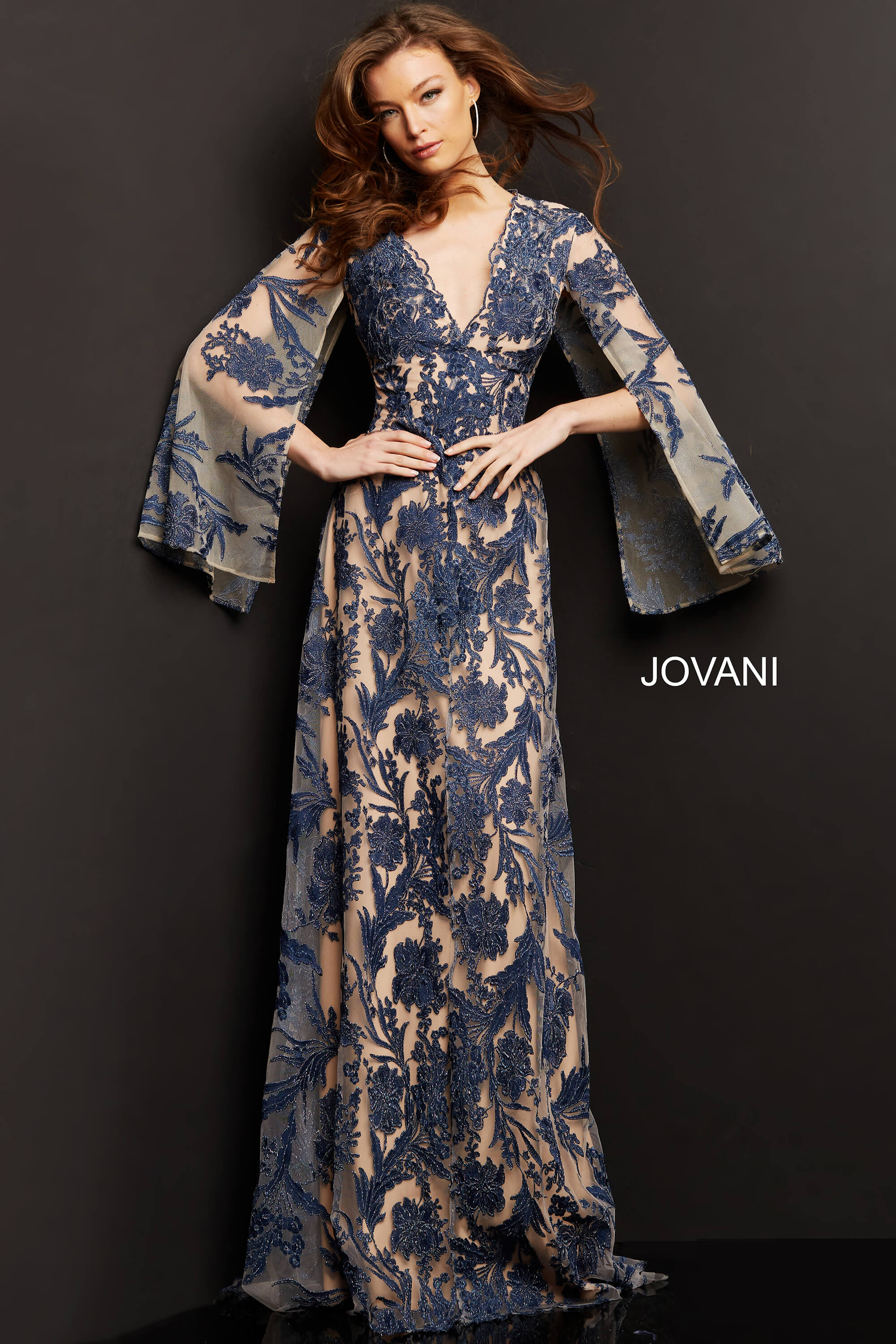 model wearing Jovani 00752 navy A-line gown with floral embroidery and bell sleeves