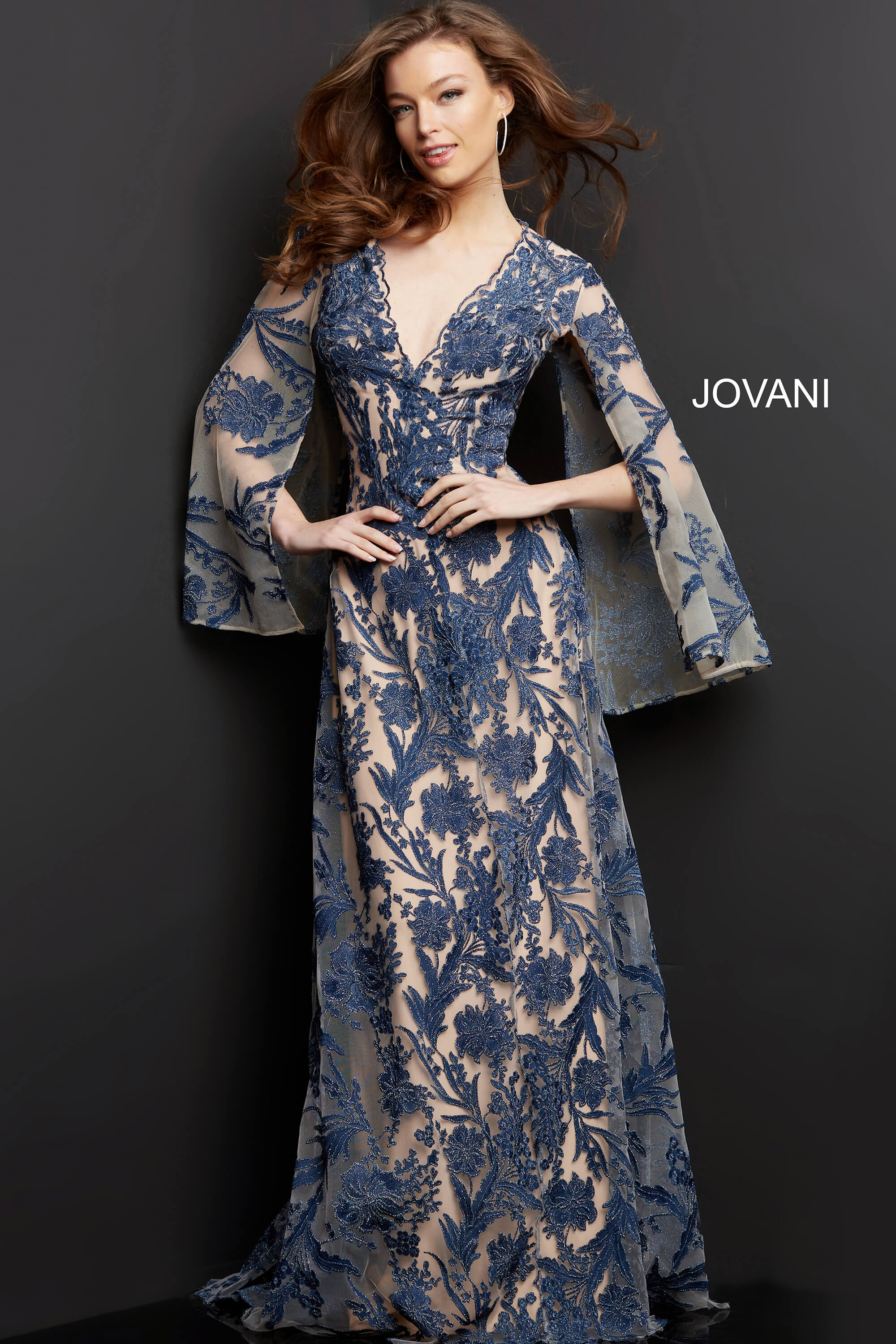 model wearing Jovani 00752 navy A-line gown with floral embroidery and bell sleeves