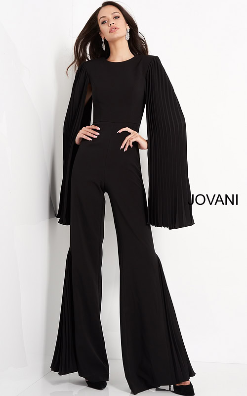 Model wearing Jovani 00756 black jumpsuit with pleated cape sleeves, front view.