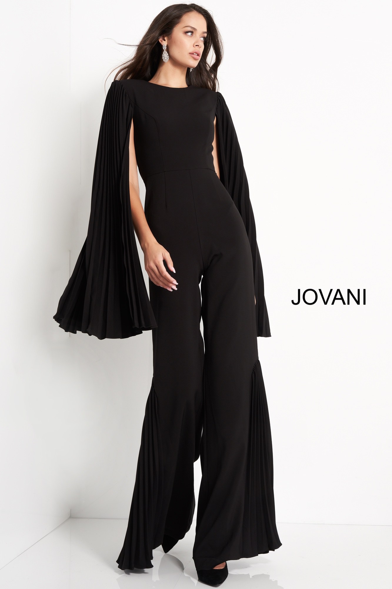 Model wearing Jovani 00756 black jumpsuit with pleated cape sleeves, alternate front view.