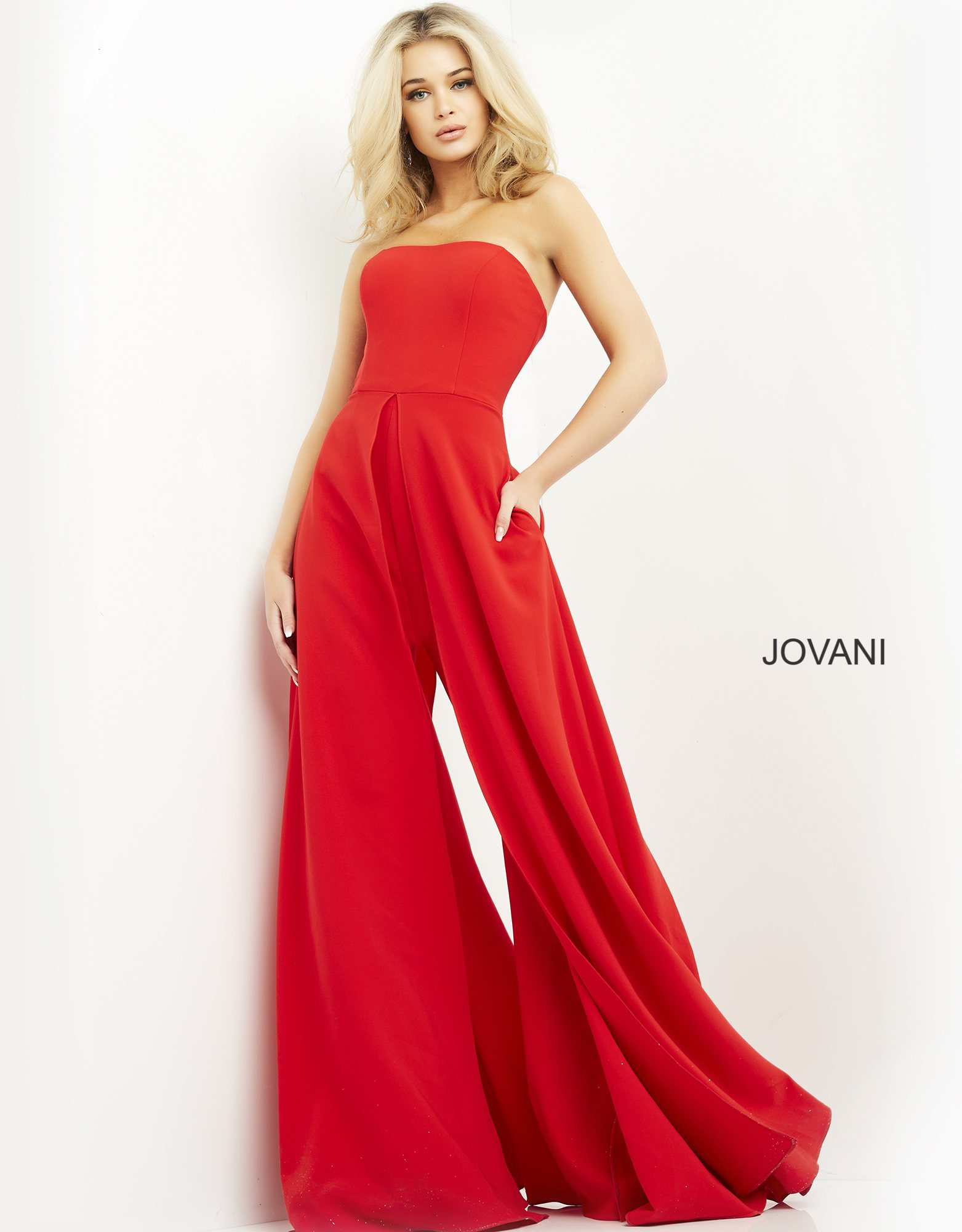 Model showcasing Jovani 03529 red dress with high front slit and strapless design.