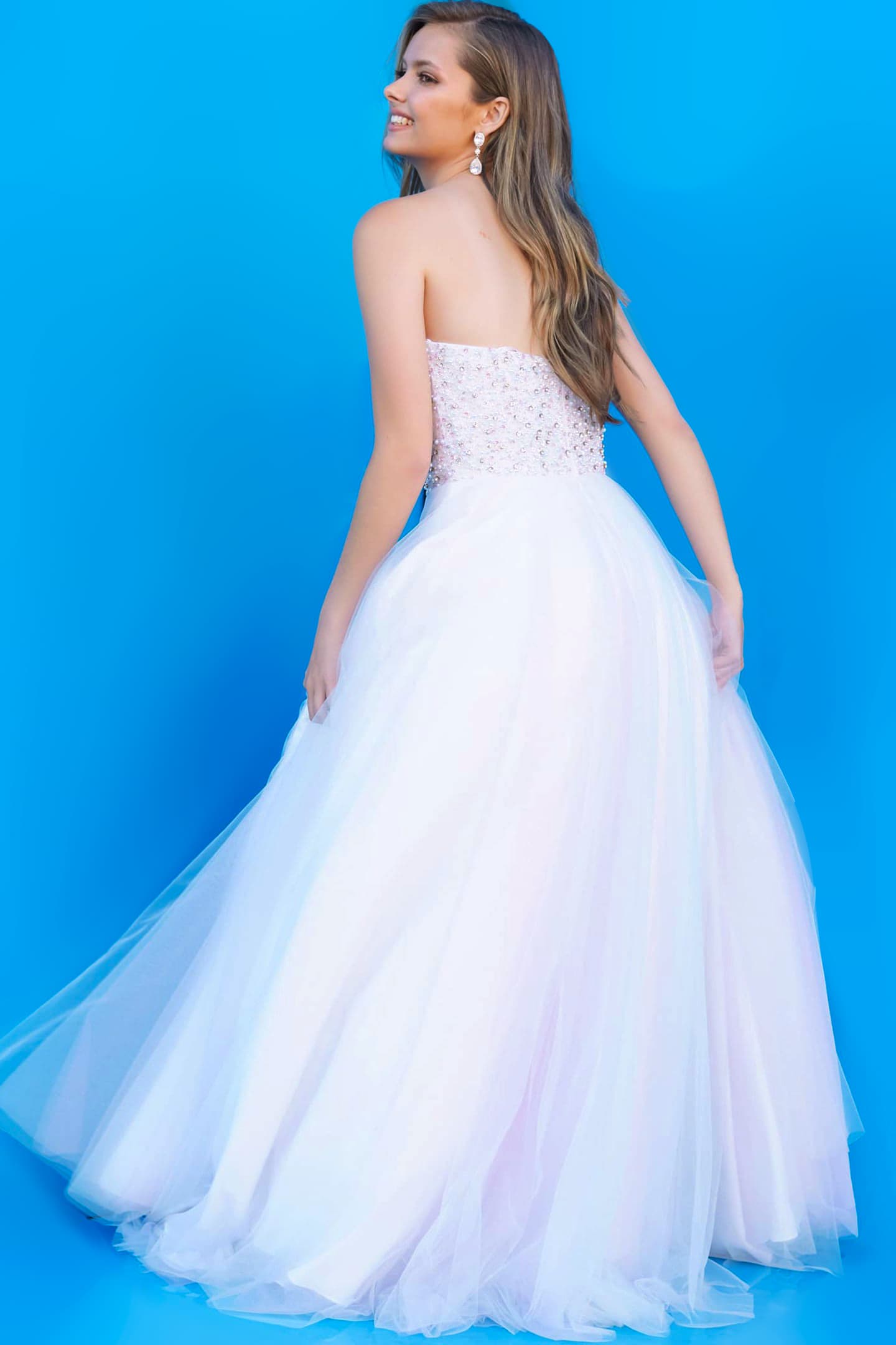 model wearing Jovani K02229 blue gown back view against blue background