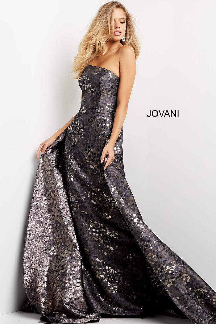 Model wearing Jovani 06255 gray gown showcasing intricate detailing with a relaxed pose.