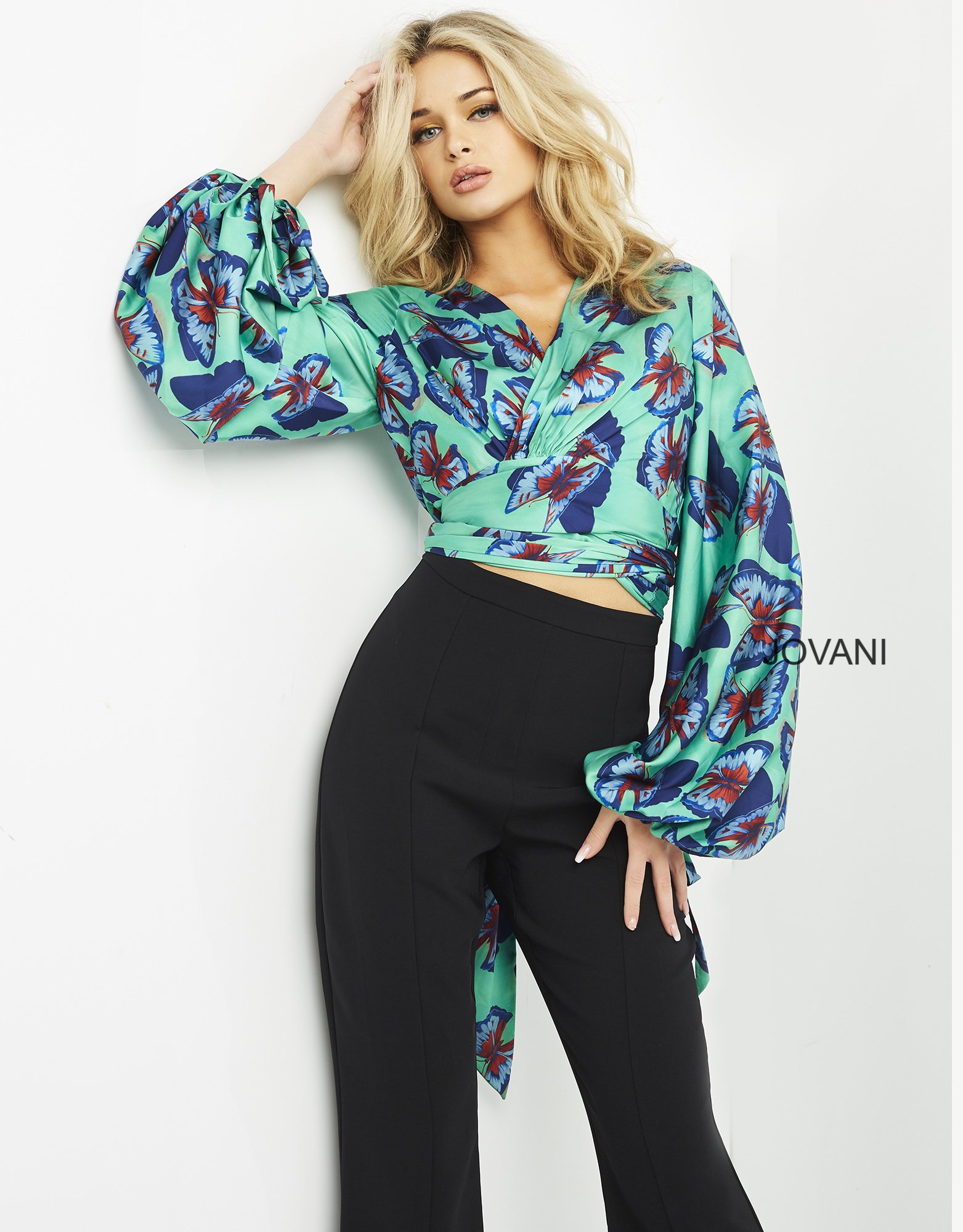 Model wearing Jovani 06844 vibrant print ensemble with crop top and long sleeves.