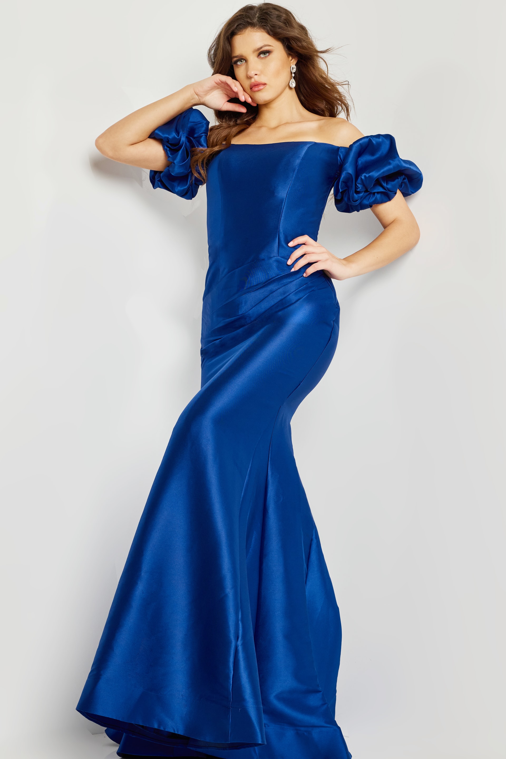 Model posing in Jovani 08361 indigo mermaid gown with off-shoulder puff sleeves.