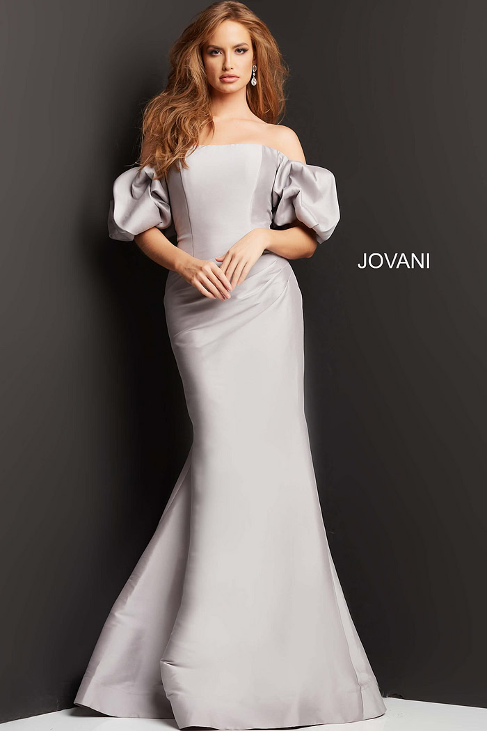 Model wearing Jovani 08361 taupe mermaid gown with off-shoulder puff sleeves.