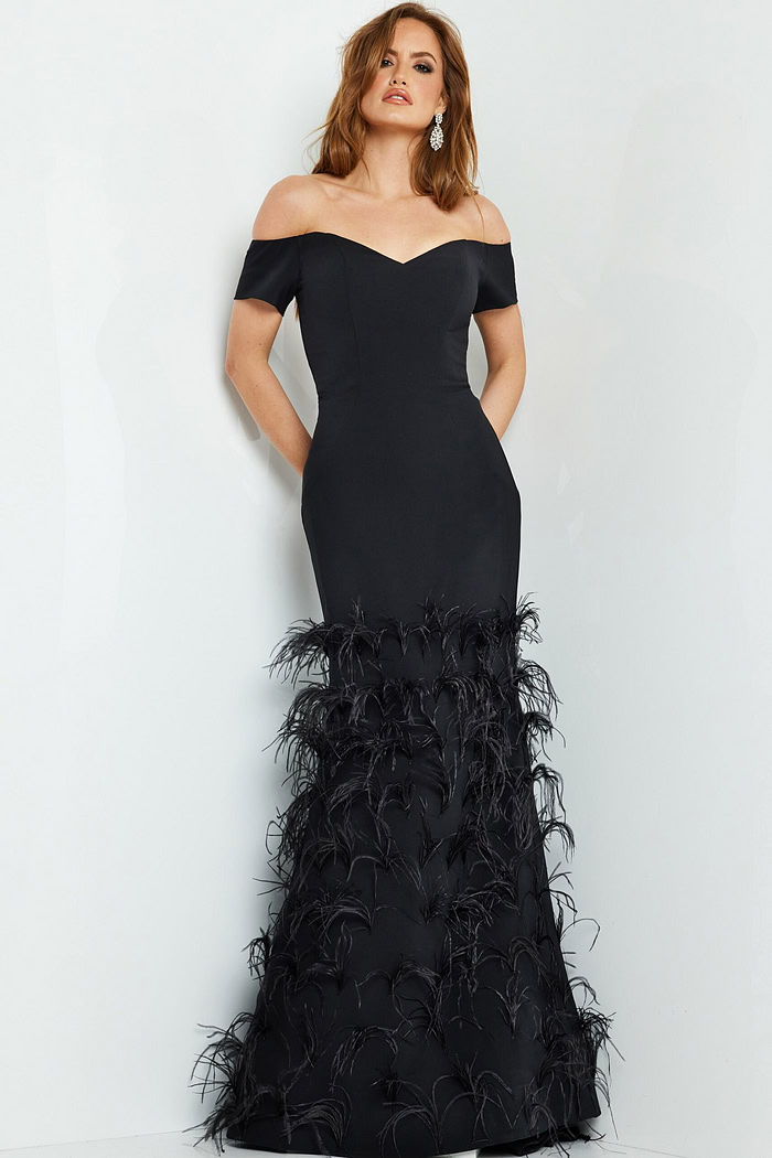 Model posing in Jovani 08384 black off-the-shoulder gown with feathered skirt.