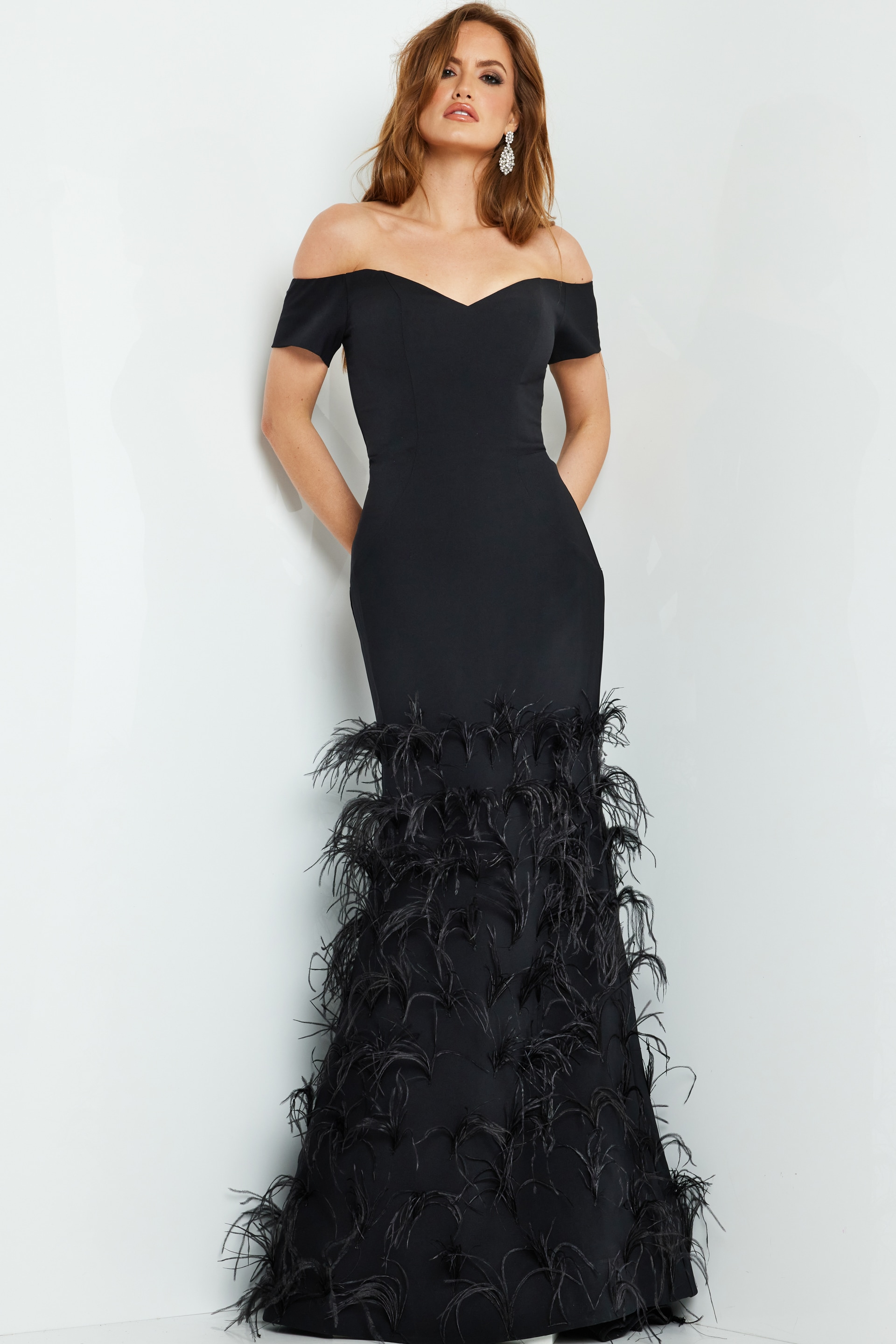Model posing in Jovani 08384 black off-the-shoulder gown with feathered skirt.
