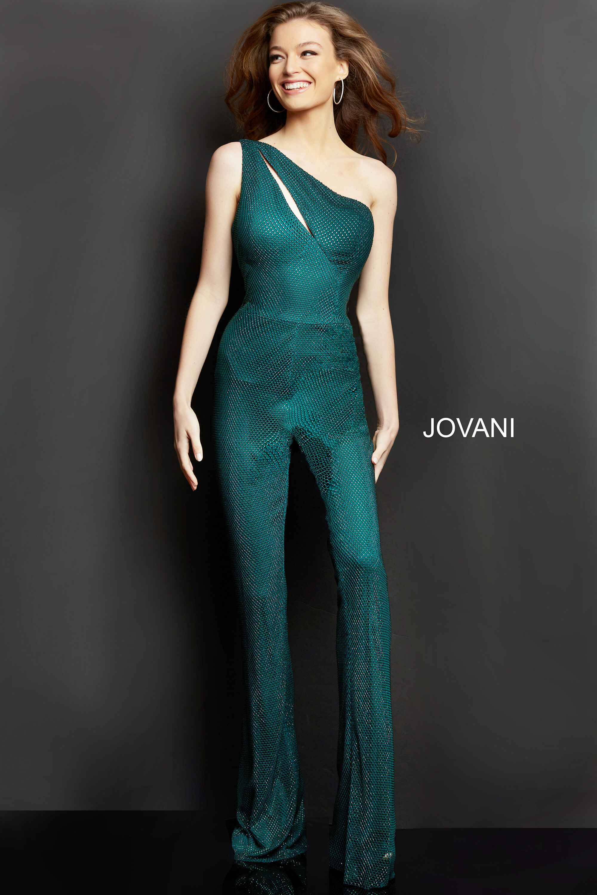 Model wearing Jovani 09018 green jumpsuit, smiling front view