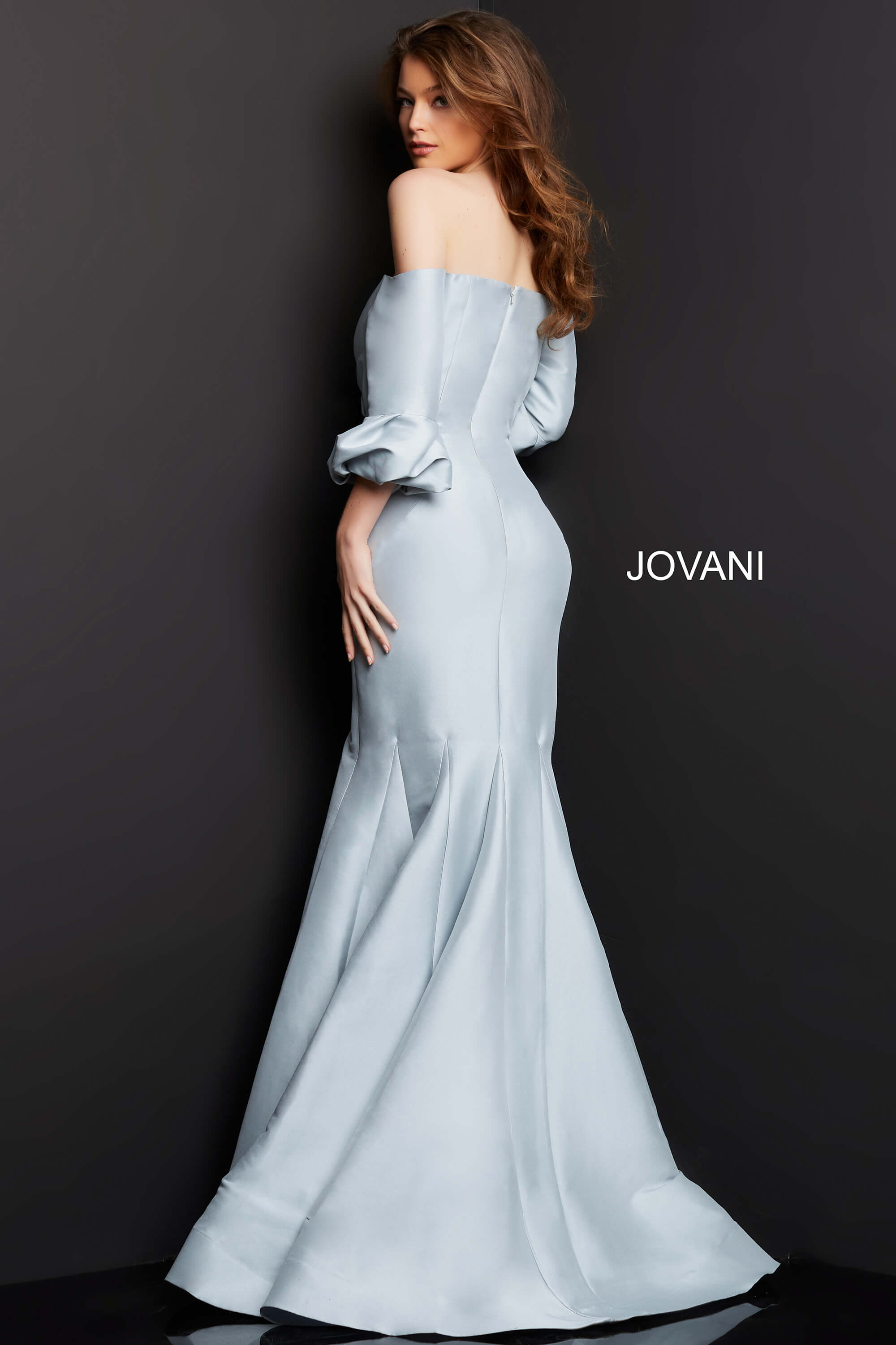 Model wearing Jovani 09420 silver dress, back view with detailed fabric draping