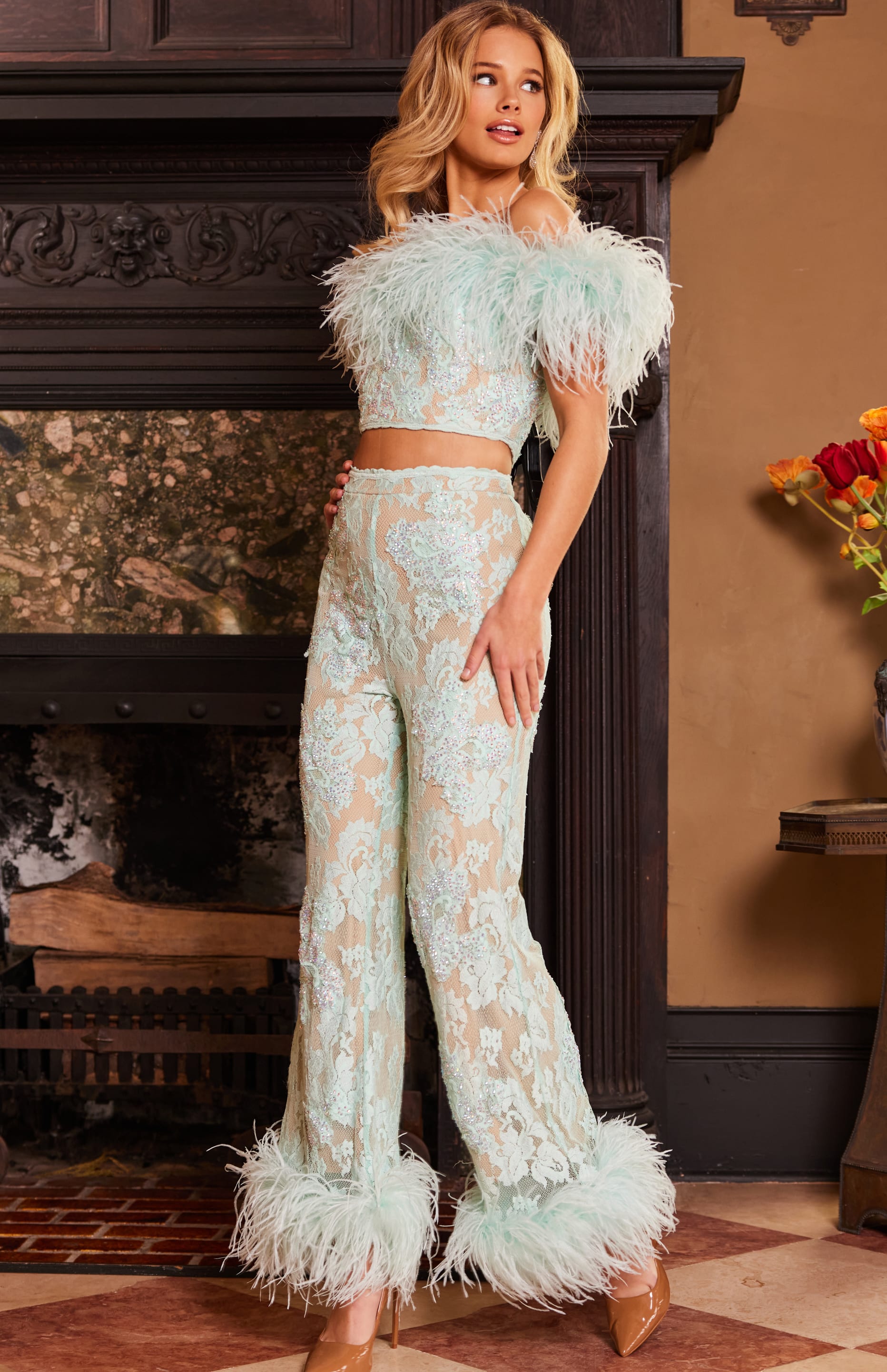 Model wearing Jovani 22350 from a side view, highlighting the intricate lacework and feathered details.