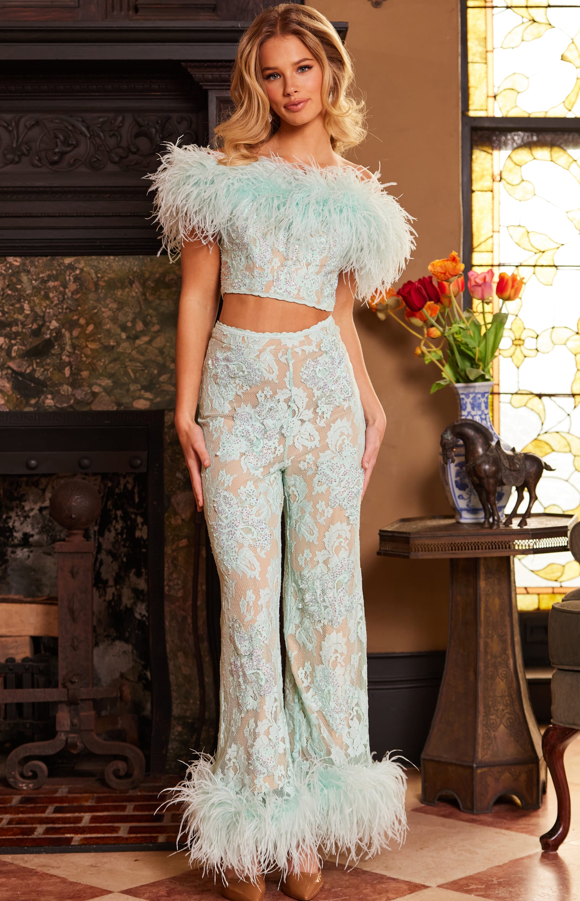 Model wearing Jovani 22350, a front view with full-length lace and feathered design.