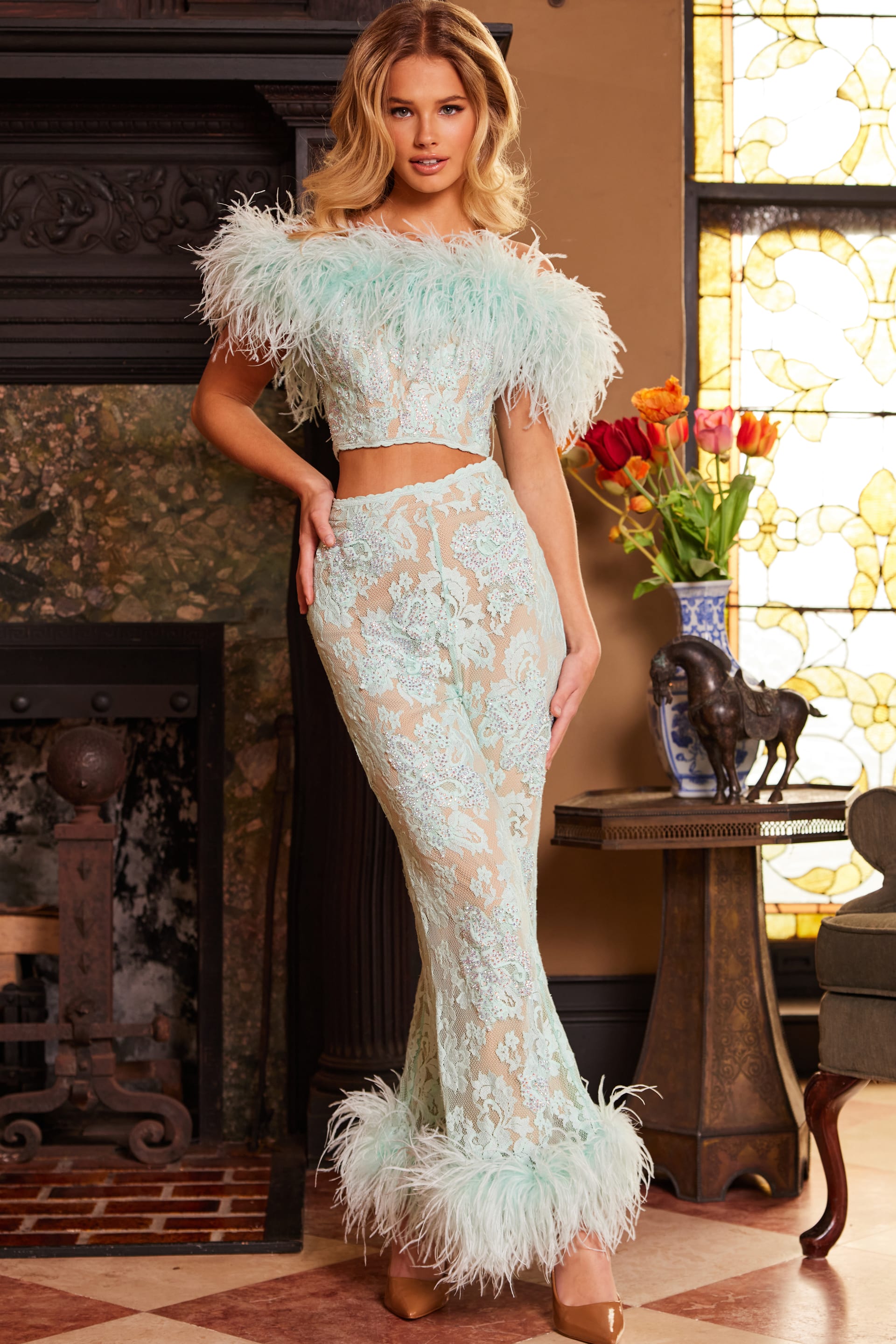Model wearing Jovani 22350, front view showing elegant off-shoulder feathers and lace.