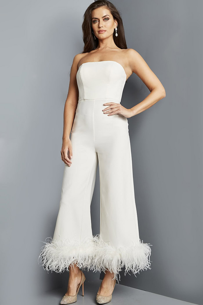 Model in Jovani 22590 ivory strapless jumpsuit featuring feathered hem, full front view.