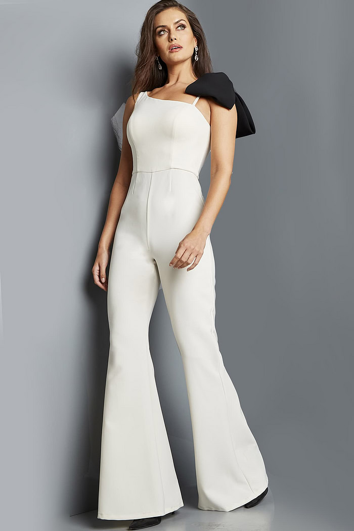 Model wearing Jovani 22589 ivory jumpsuit with asymmetrical neckline, full view.