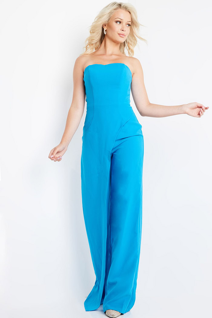 Model wearing Jovani 23082 blue strapless jumpsuit in motion.