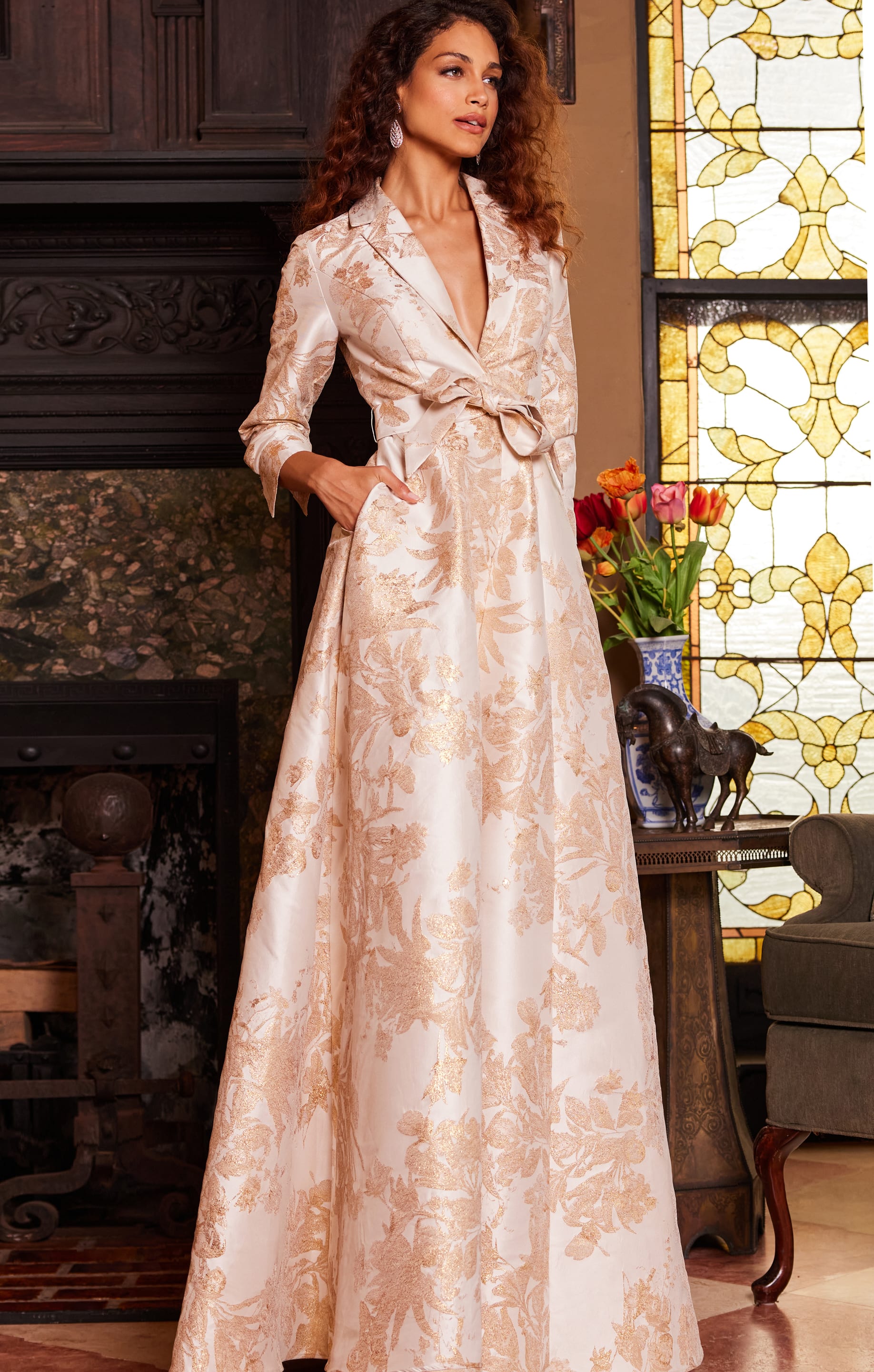 Model wearing Jovani 23178 gold floral brocade dress standing
