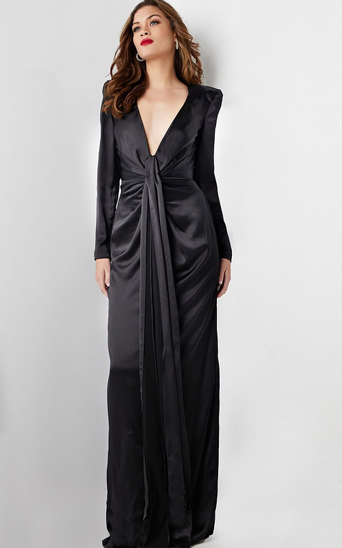 Model wearing Jovani 23180 elegant black gown with deep V-neckline and knot detail, front view.