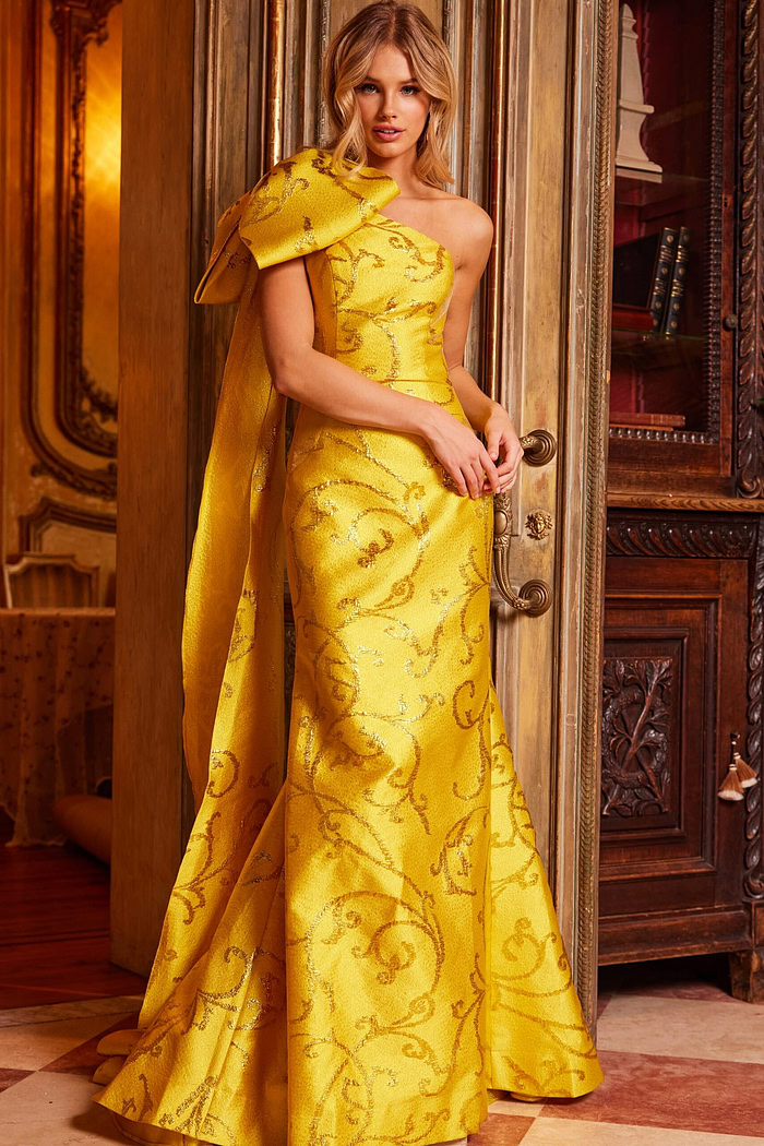 Model wearing Jovani 23742 yellow gown, front view with detail on oversized shoulder bow.