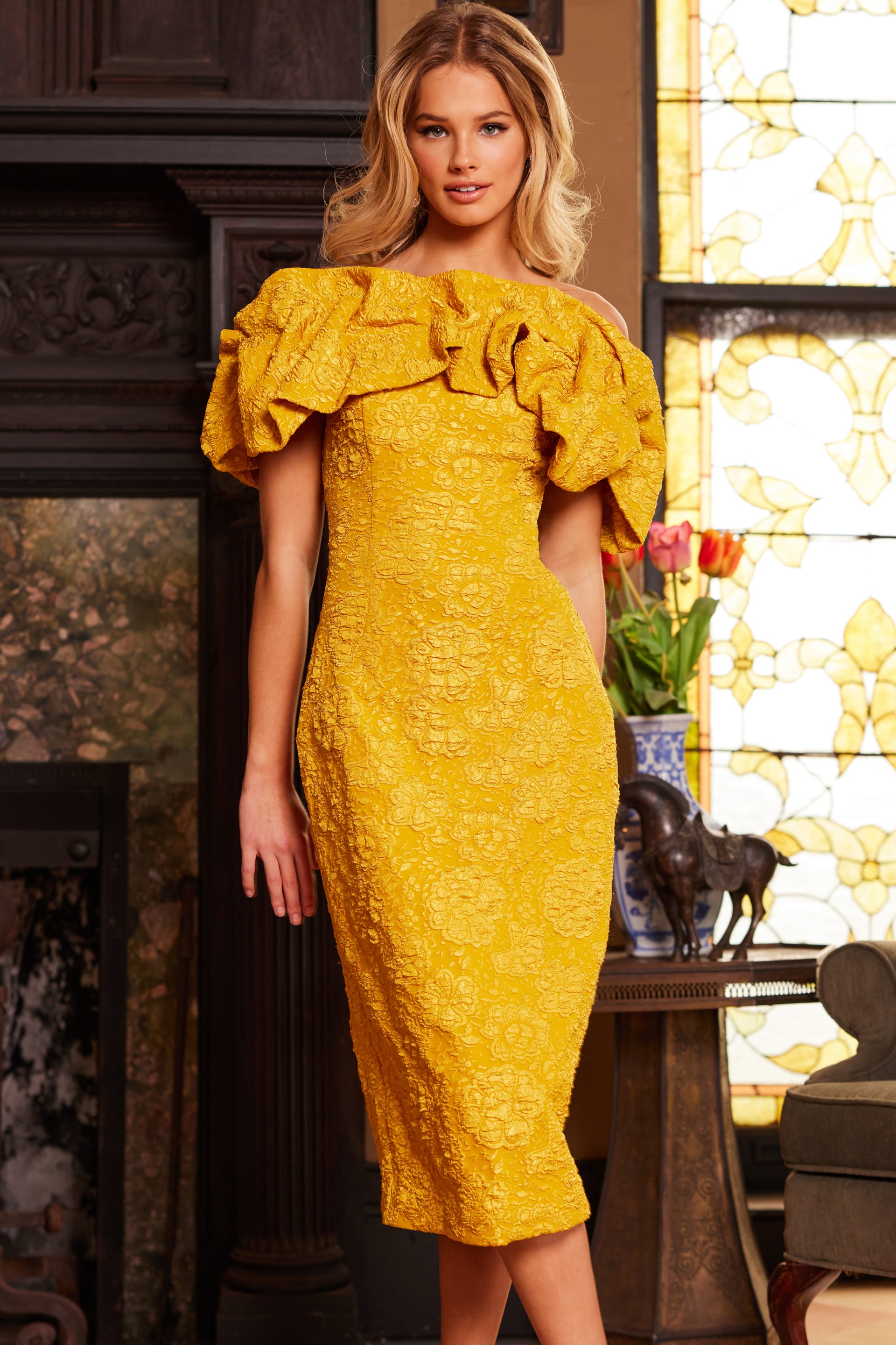 Model wearing Jovani 23848 yellow dress with off-the-shoulder neckline and ruffles, front view.
