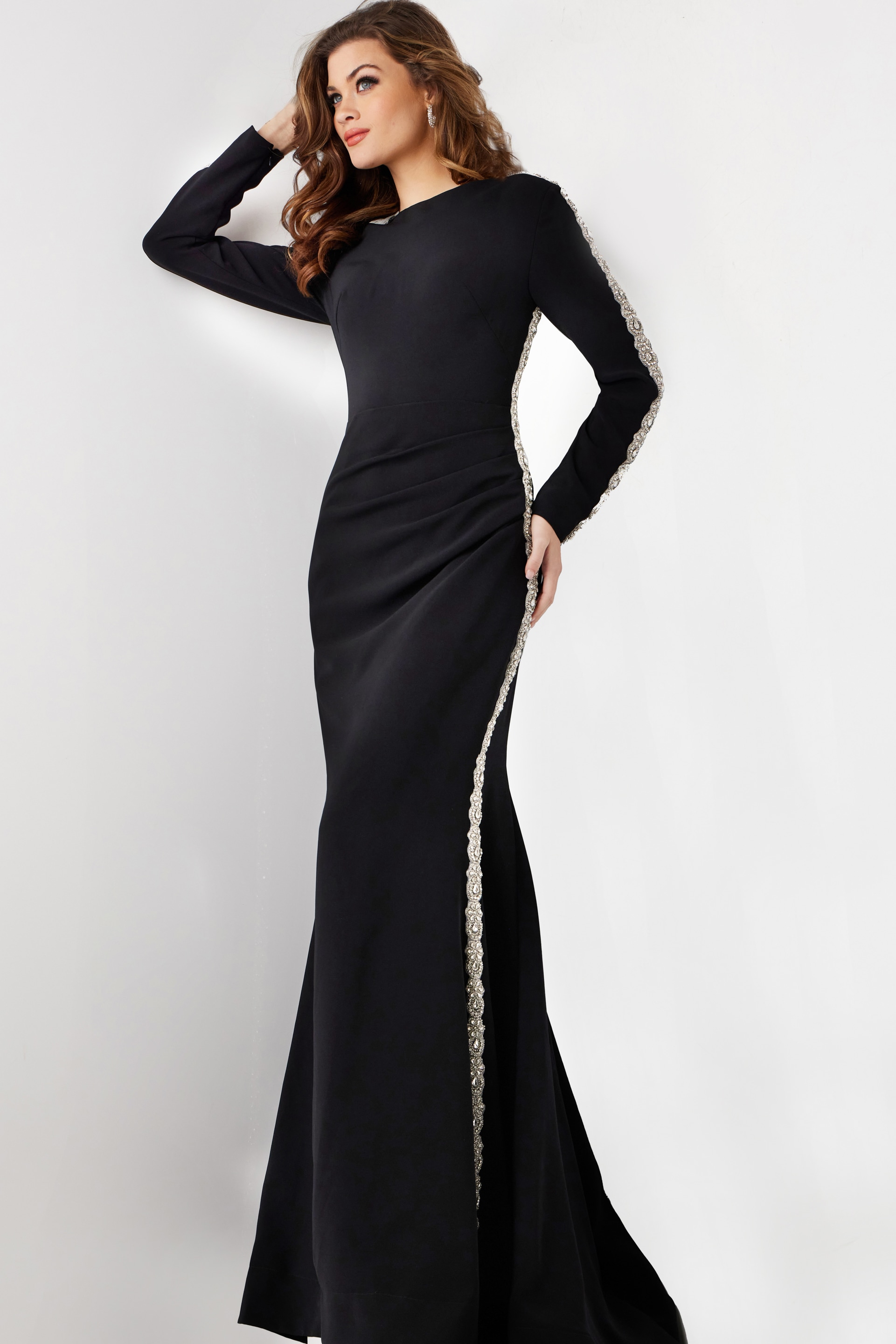 model wearing Jovani 24191: black mermaid gown with silver embellishment, side view
