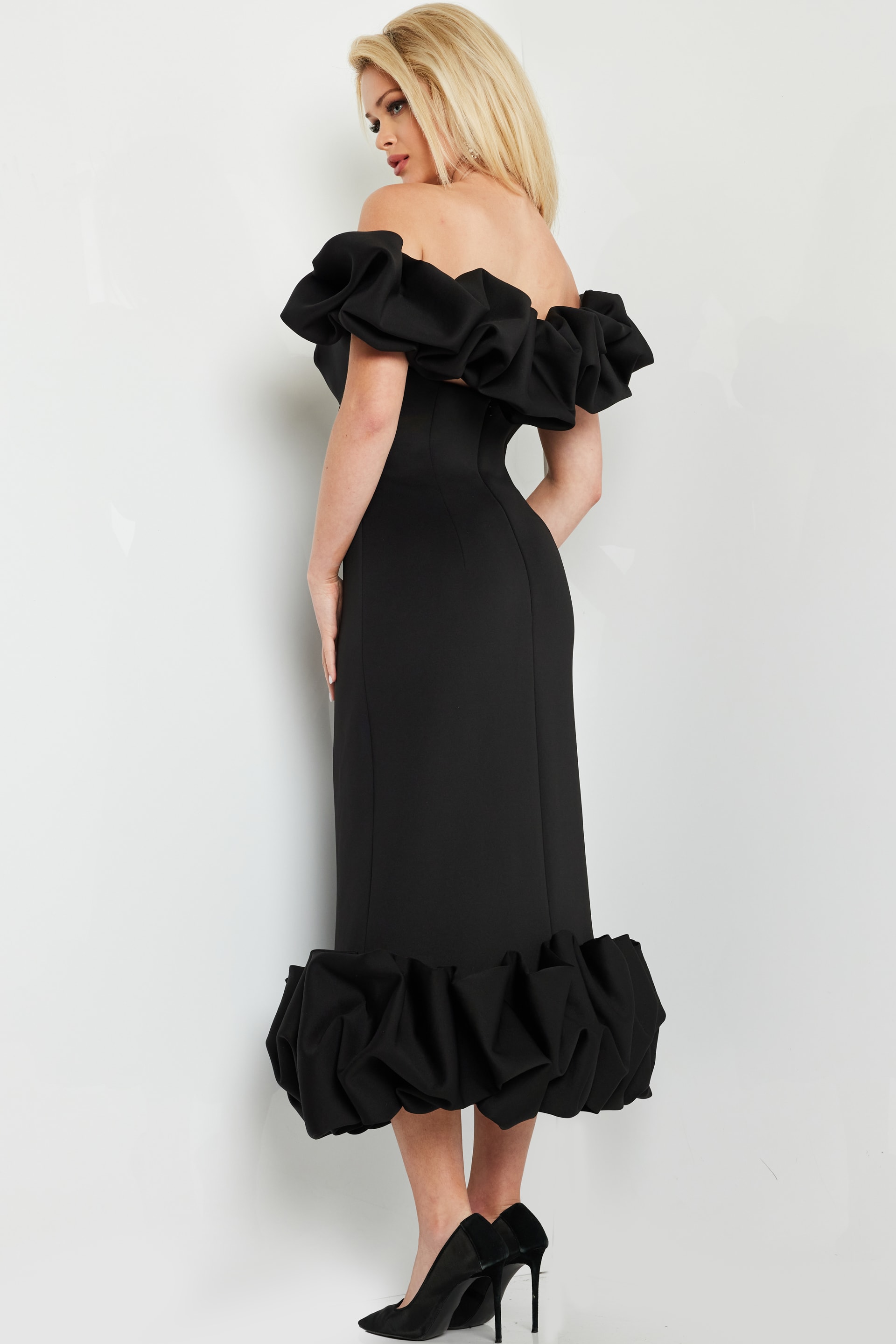 model wearing Jovani 24535 black dress with ruffled sleeves, back view