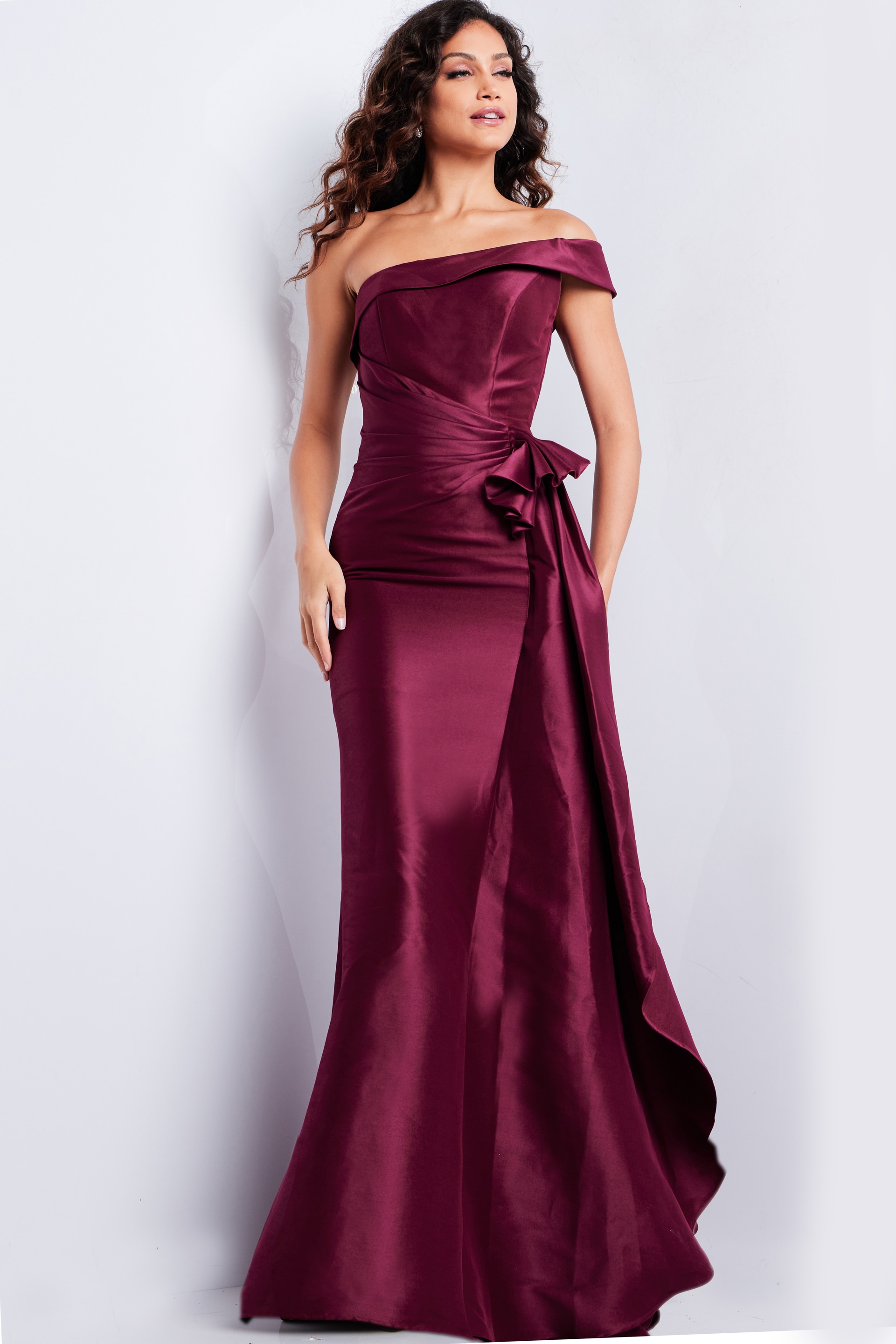 Model wearing Jovani 25831 burgundy off-shoulder dress with floor-length design.
