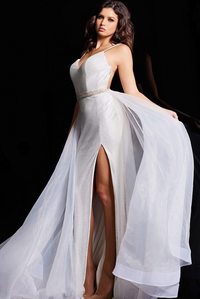 Model showcasing Jovani 25990 white gown with intricate beadwork and high slit.