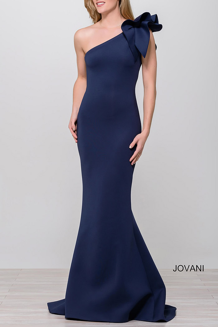 Model in Jovani 32602 navy gown, one-shoulder with bow