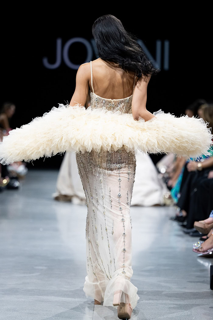 Model wearing Jovani 36510 showing a back view of the nude dress with elegant detailing.
