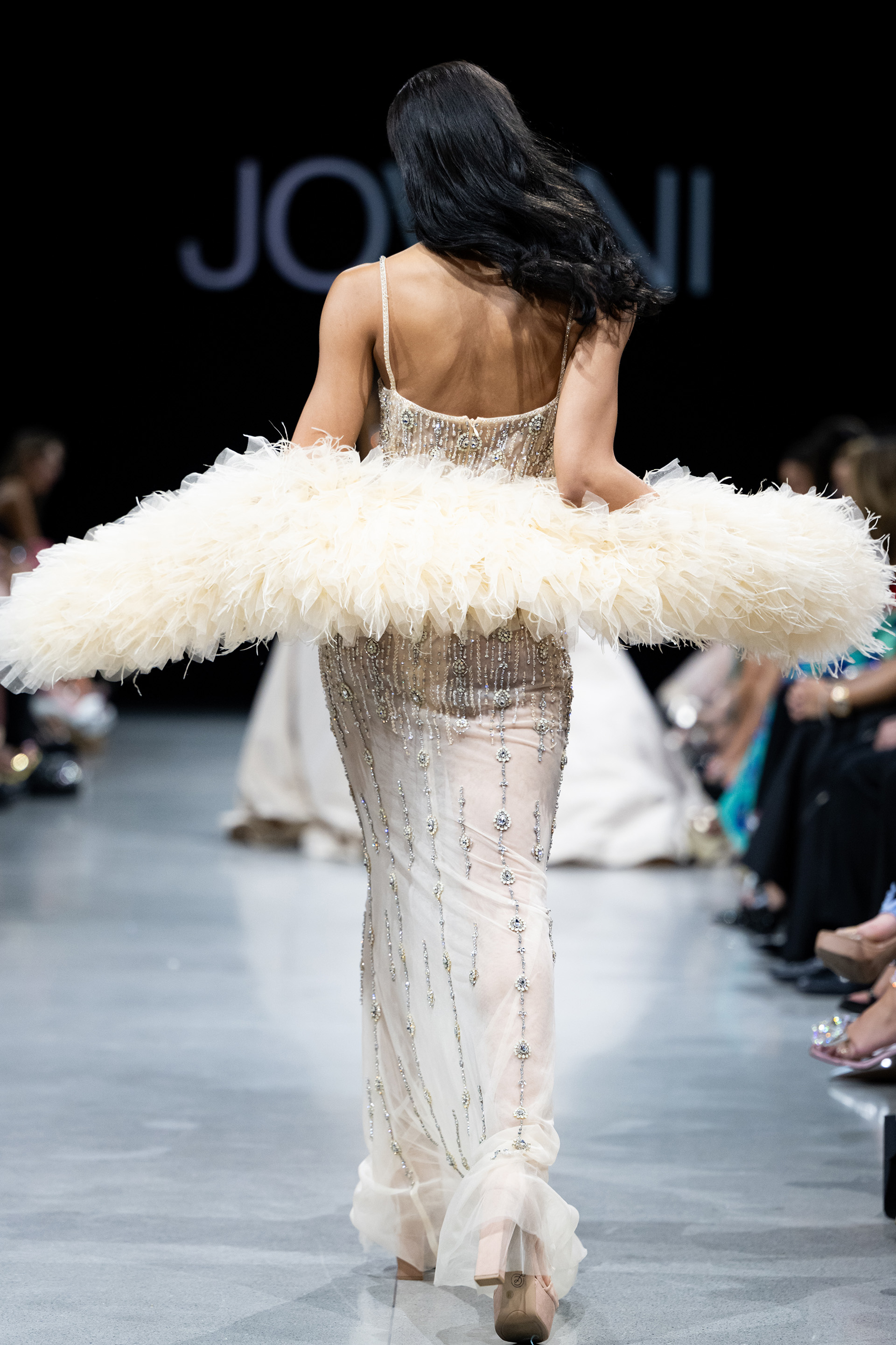 Model wearing Jovani 36510 showing a back view of the nude dress with elegant detailing.