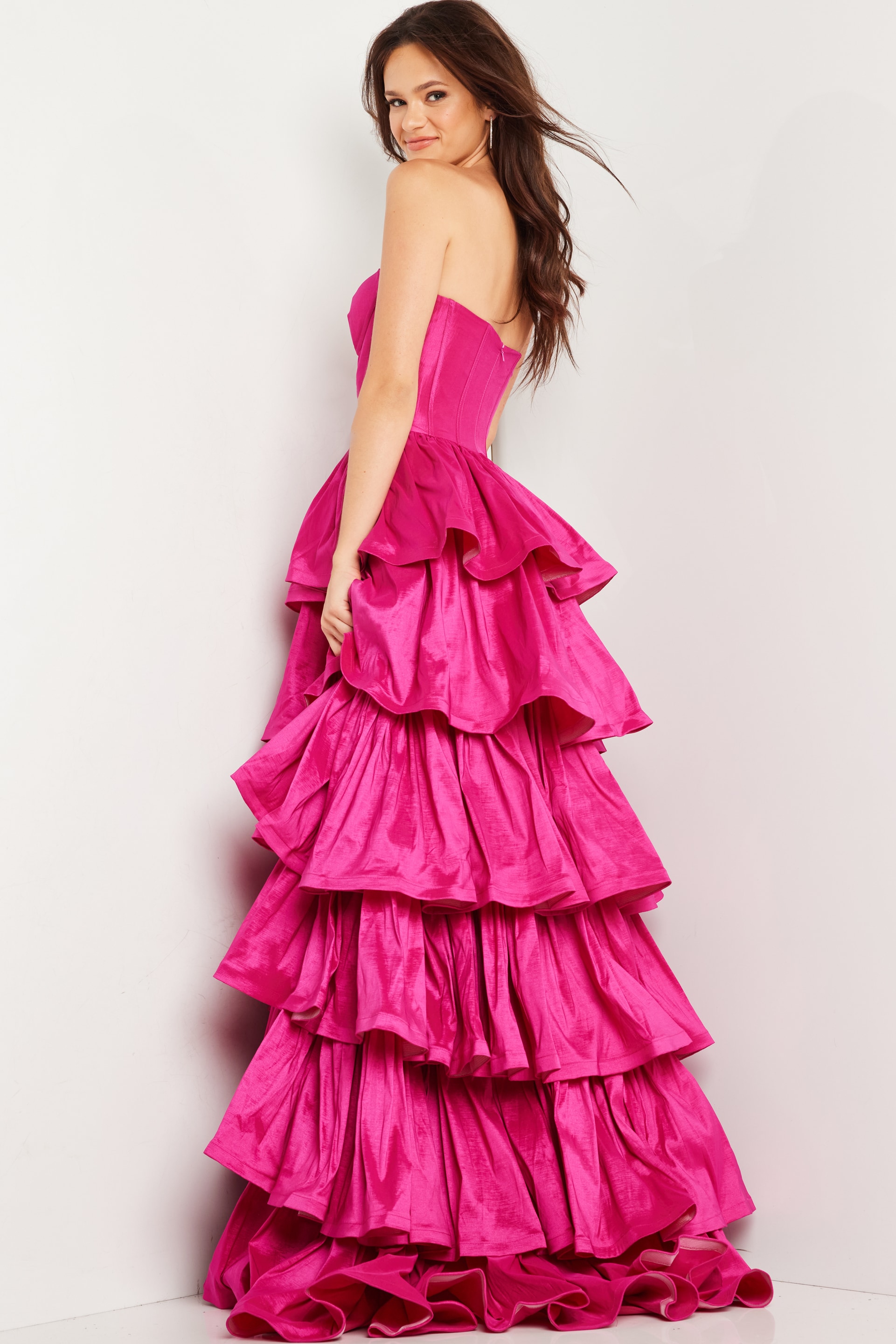 Model wearing Jovani 36619 fuchsia ball gown, side view.
