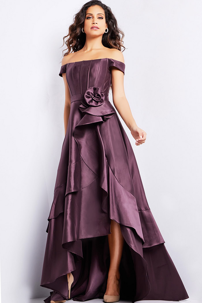 Front view of model in Jovani 37014 brown dress, highlighting the off-shoulder neckline and rosette waist detail.