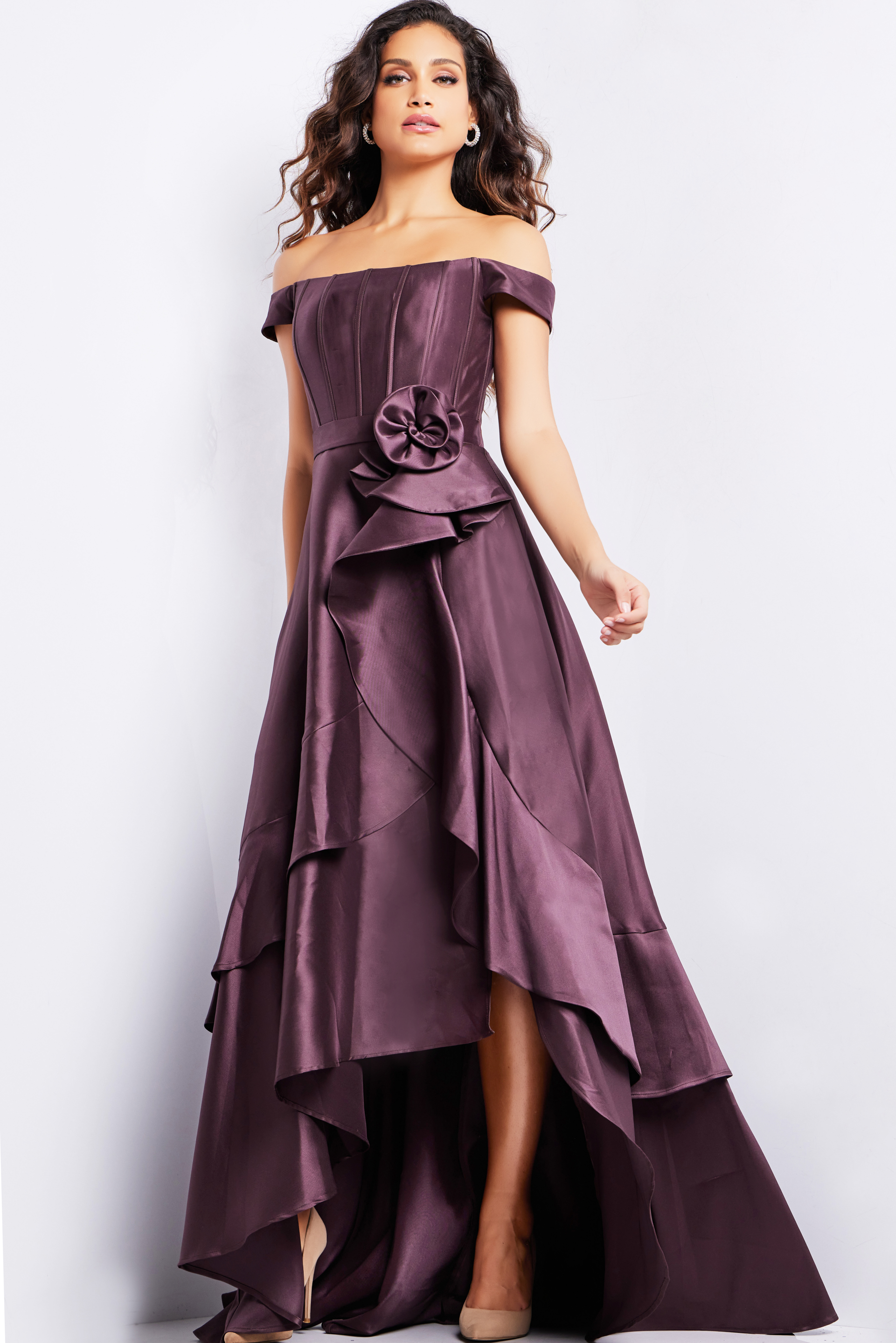 Front view of model in Jovani 37014 brown dress, highlighting the off-shoulder neckline and rosette waist detail.