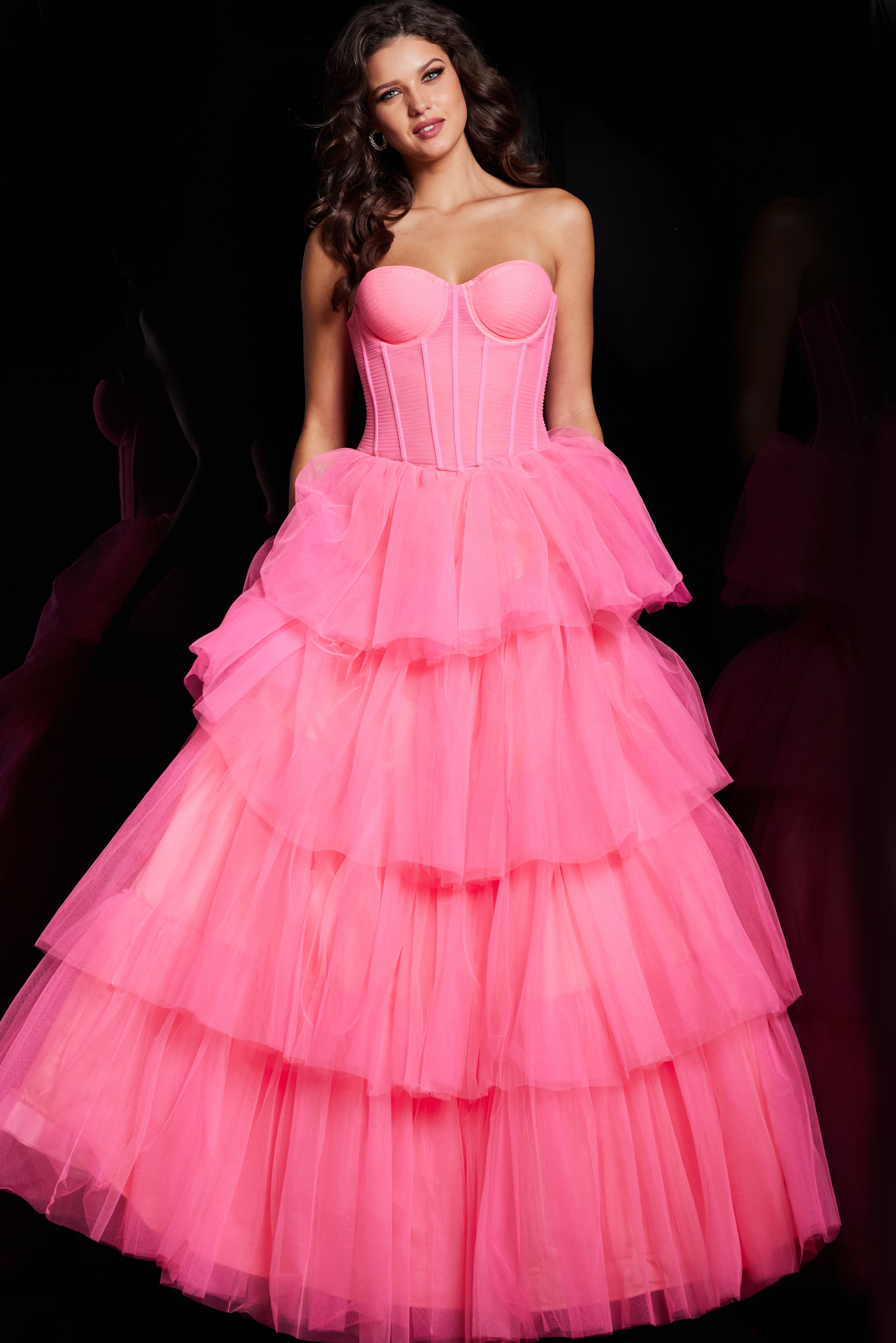 Model wearing Jovani 37062 pink gown with strapless neckline and tiered skirt, front view.