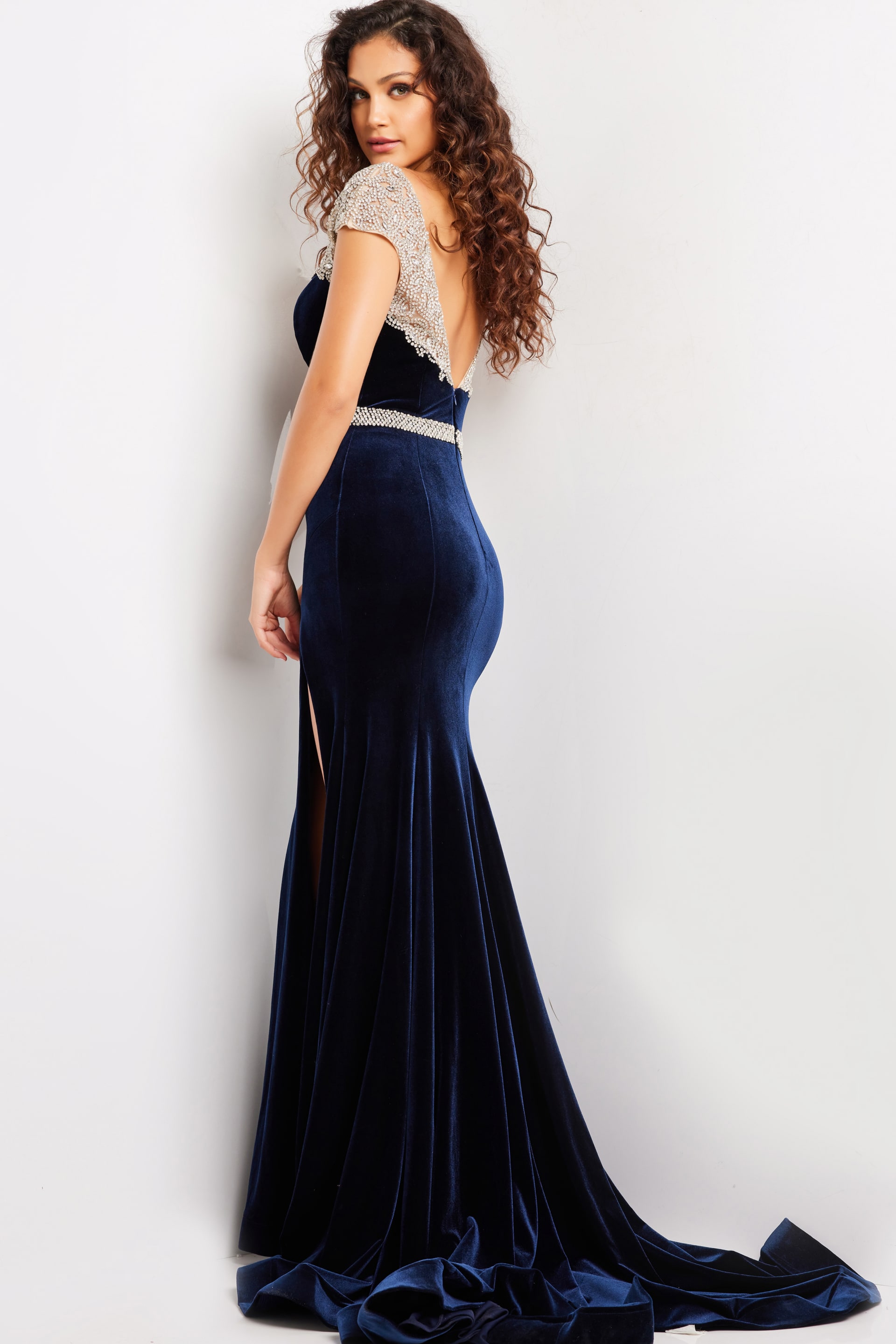 Back view of Jovani 37246 navy gown featuring a low-cut and flowing velvet skirt.