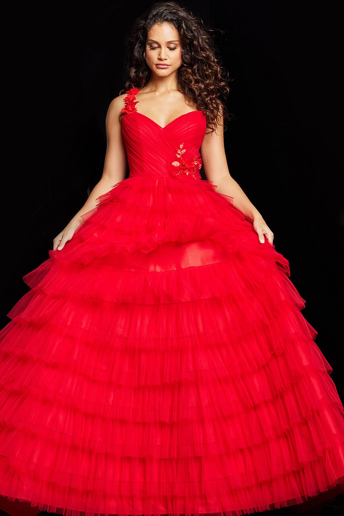 Model showcasing Jovani 37274 red dress's tiered skirt and floral shoulder appliqué.