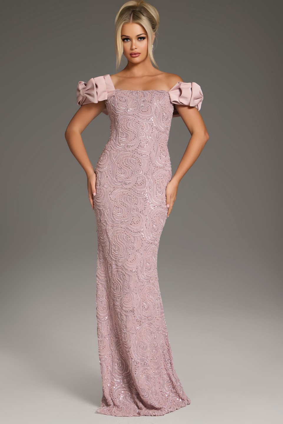 Model wearing Jovani 38112 blush mermaid gown with off-shoulder ruffled sleeves, front view.