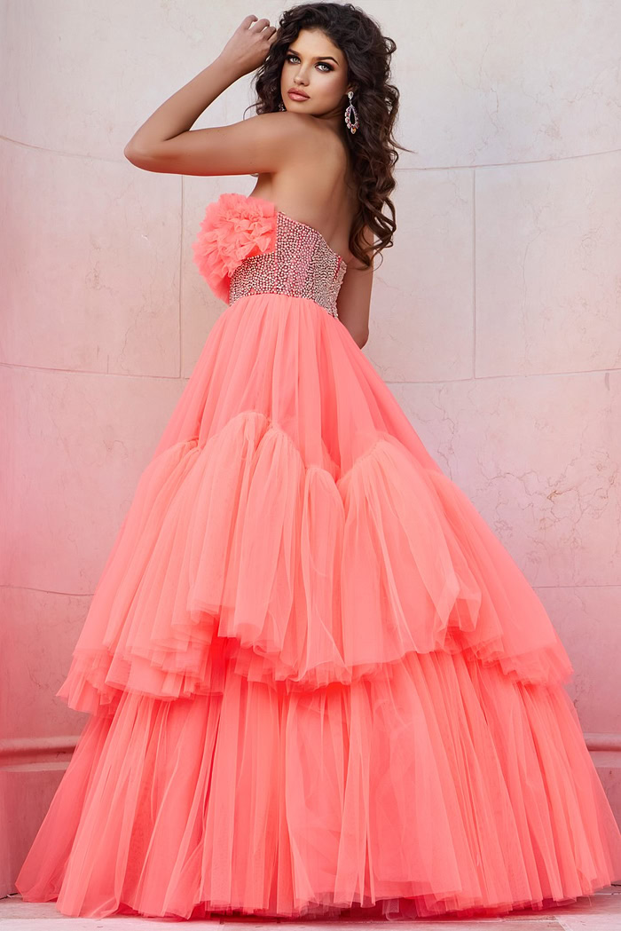 Model wearing Jovani 38299 orange gown with floral ruffles and embellished waist, side view.