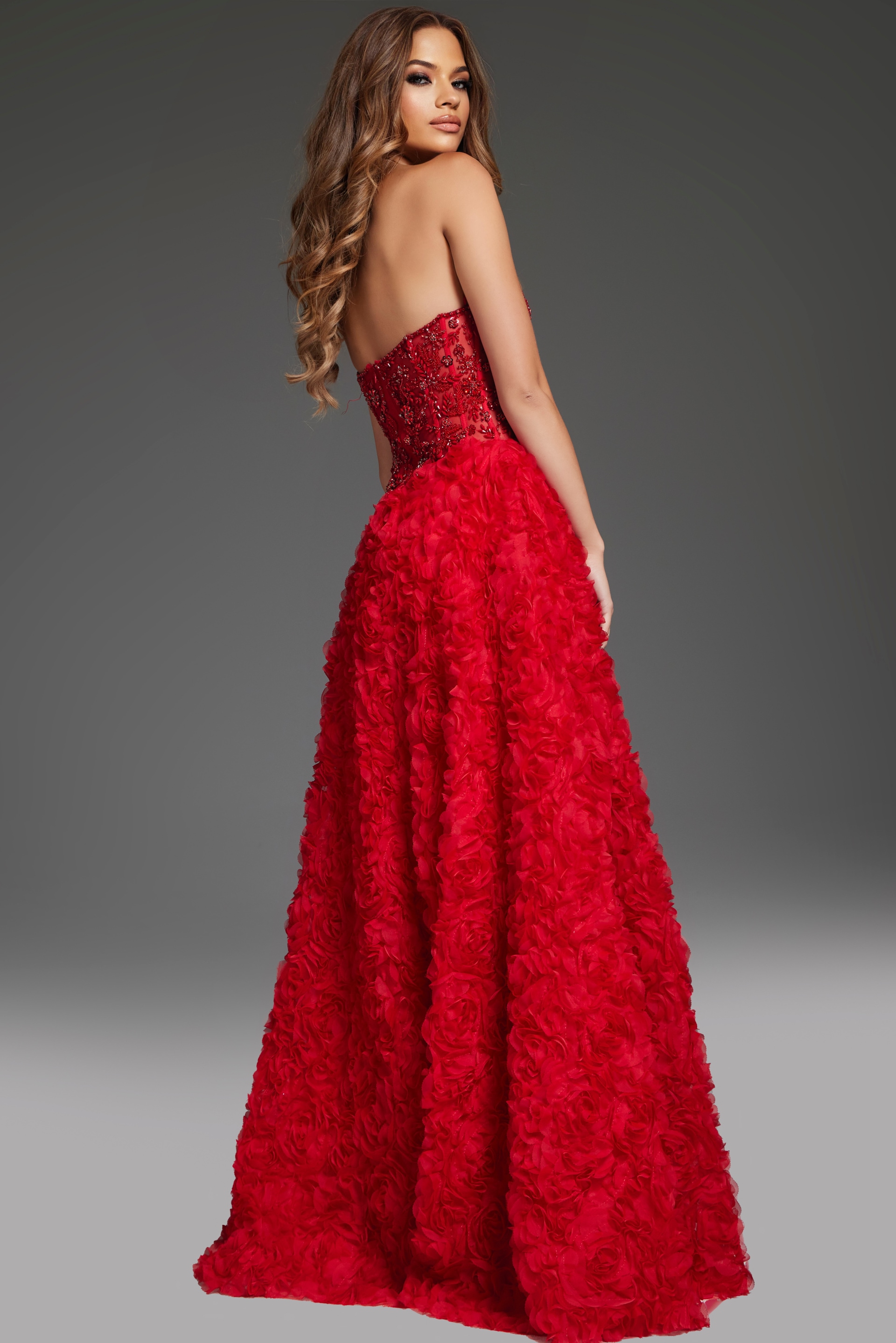 back view of model wearing Jovani 38317 red gown highlighting exquisite detailing