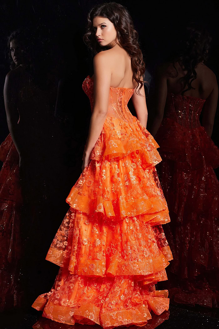 Back view of model in Jovani 38528 orange gown with layered skirt