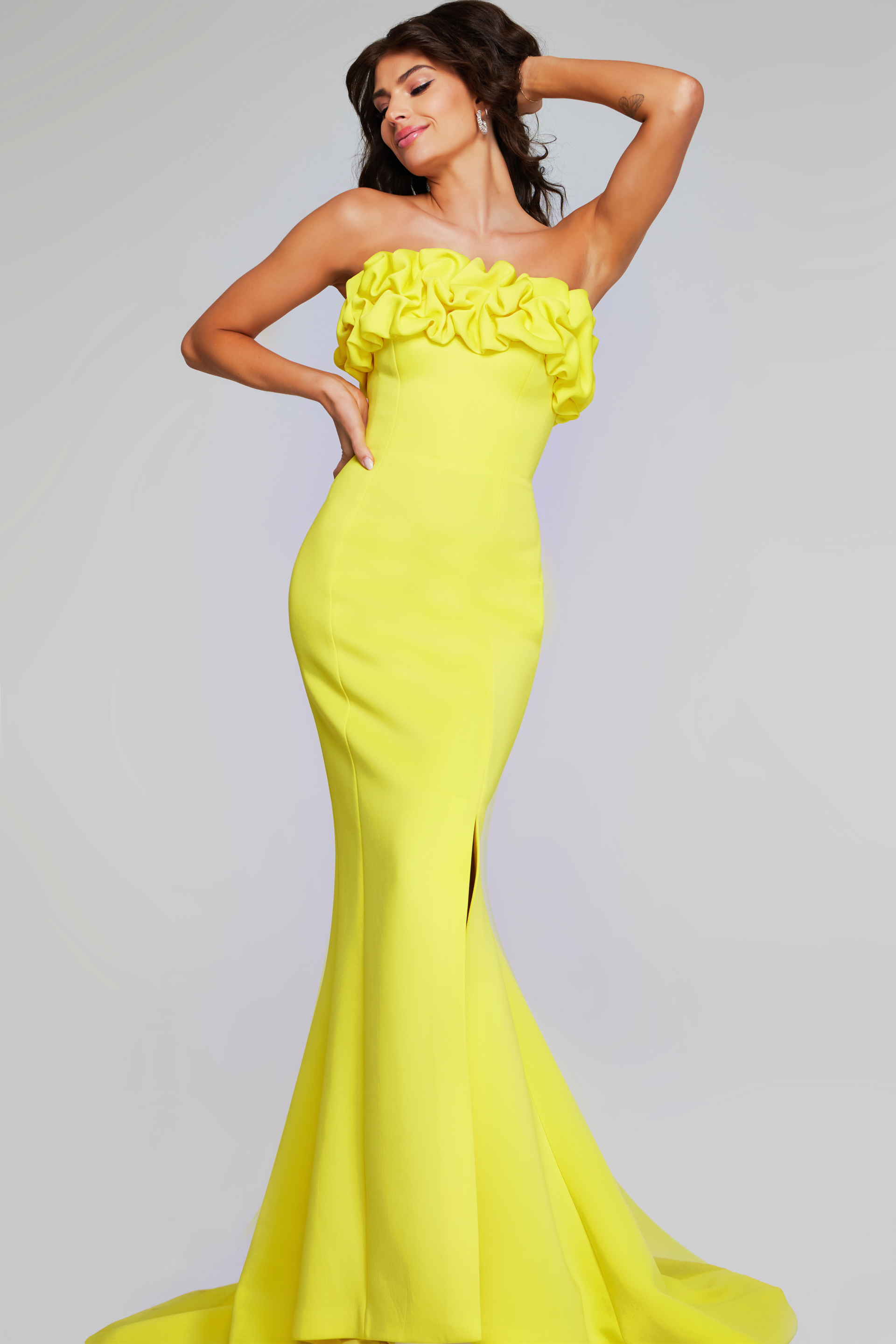 Model wearing Jovani 38922 in yellow, front view with ruffled neckline.