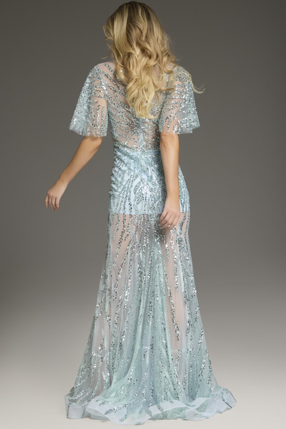 Back view of model wearing Jovani 39008 blue gown with glittering accents.