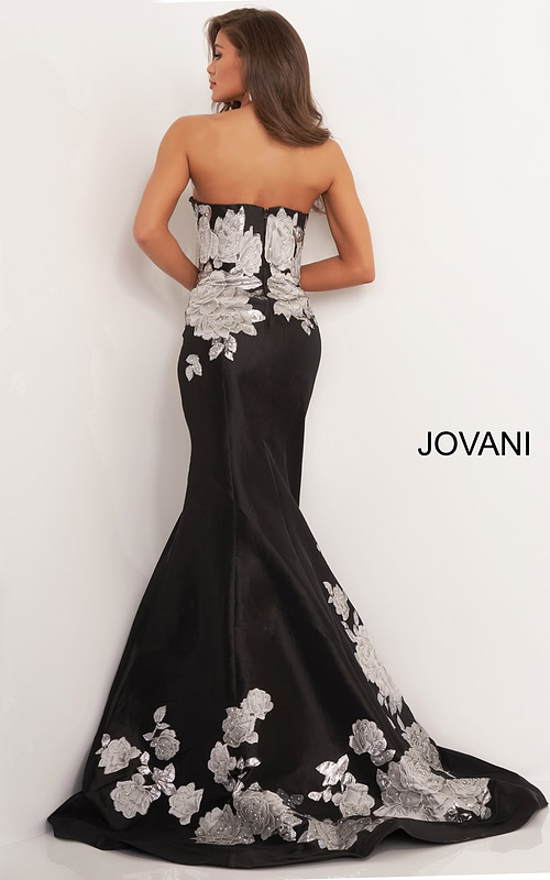 Model wearing Jovani 3917 black gown with silver floral embroidery from the back view.