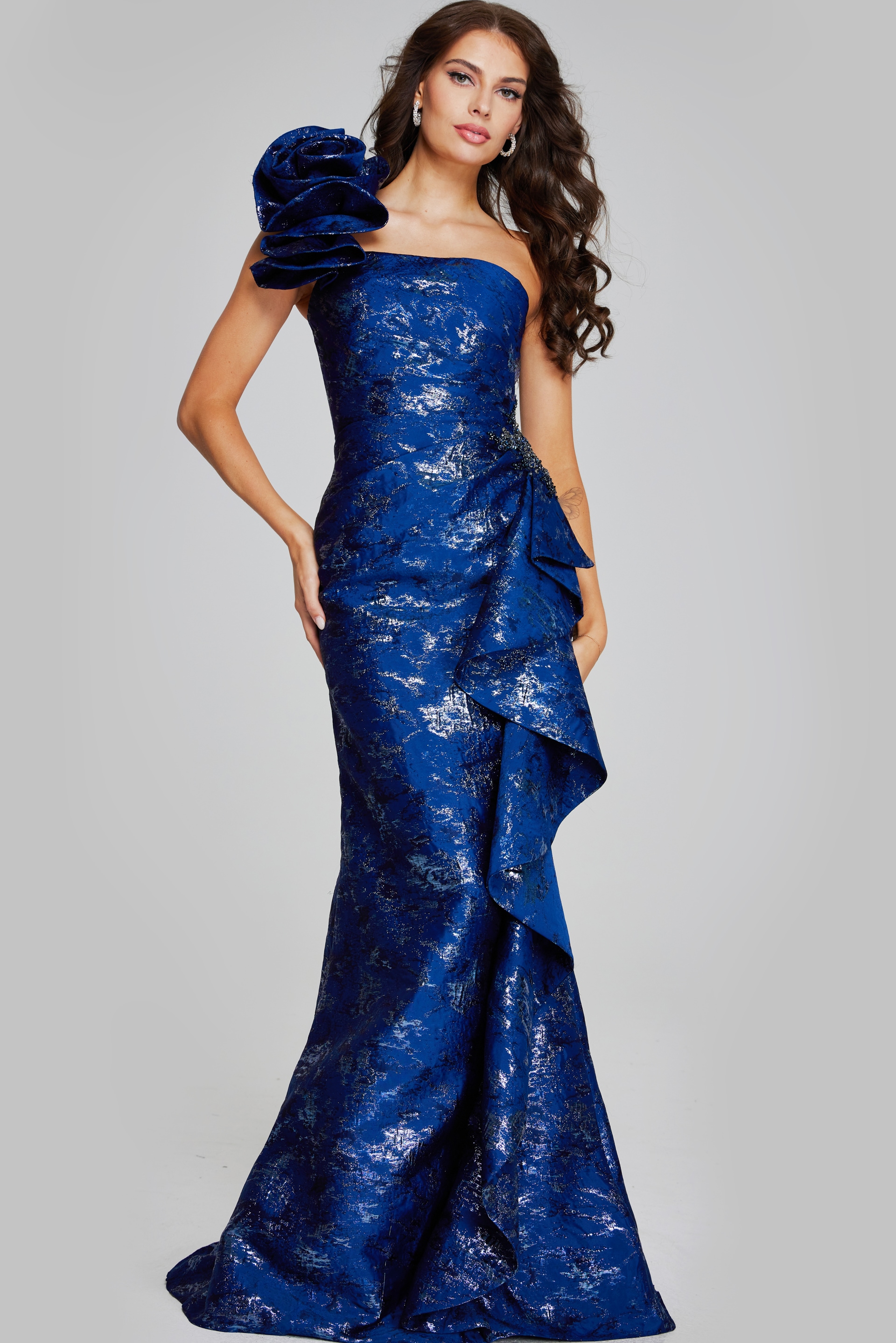Model wearing Jovani 39438 navy dress with one-shoulder floral detail and mermaid silhouette.