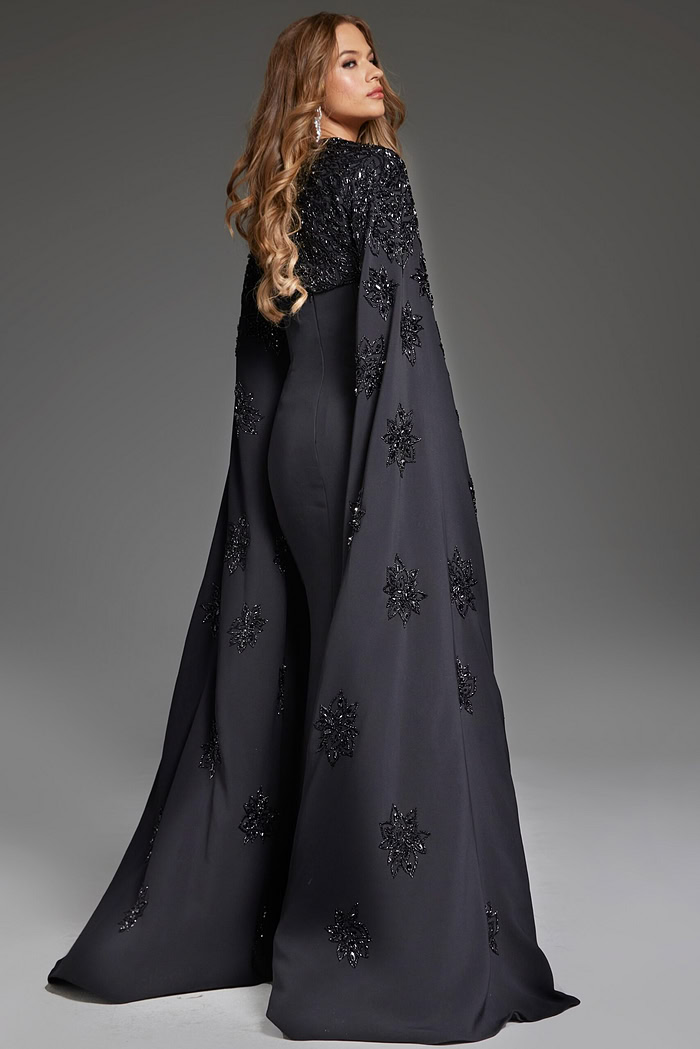 back view of model wearing Jovani 39957 black gown highlighting the dramatic cape
