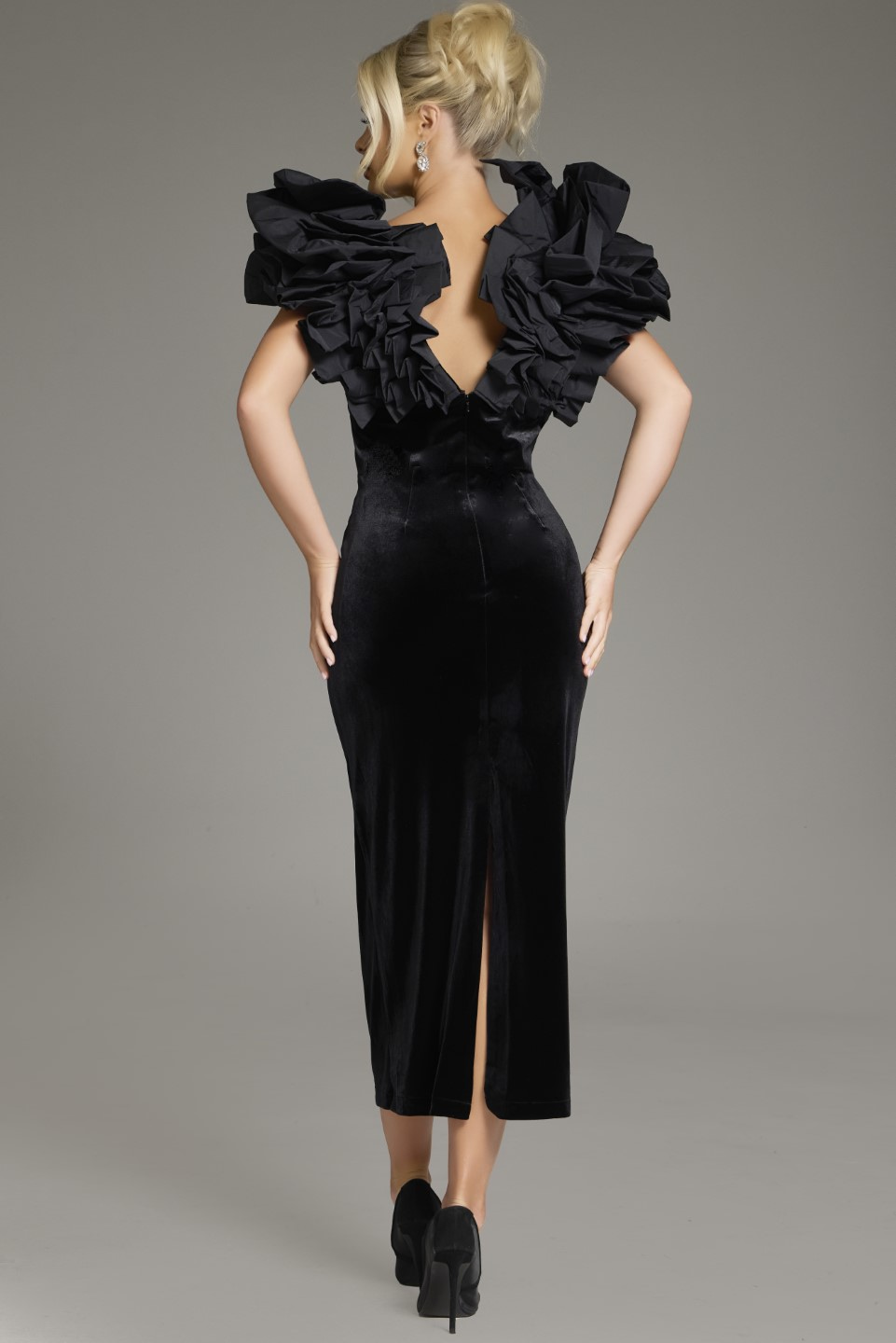 Model wearing Jovani 39978 black dress, back view with ruffled shoulders