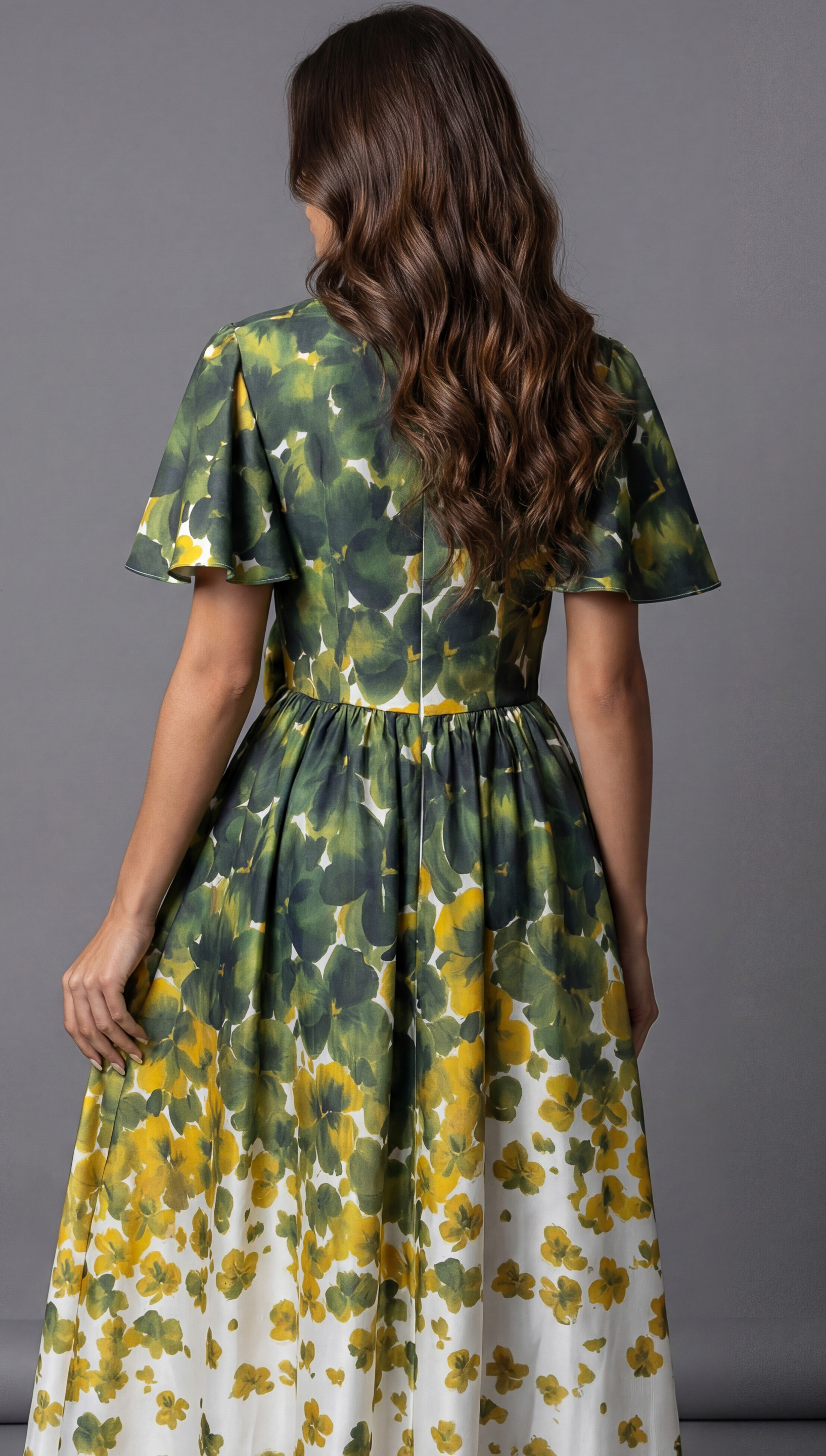 Back view of a long floral evening dress with flutter sleeves and a softly gathered waist