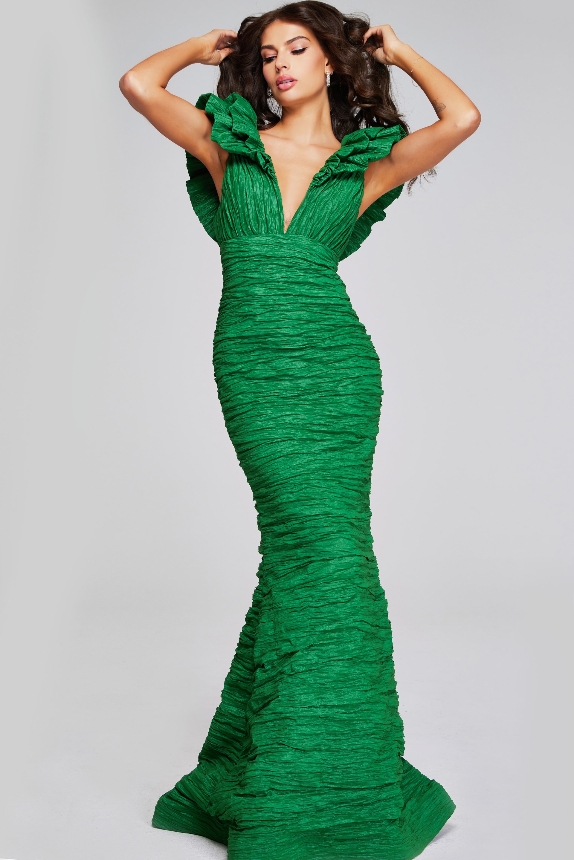 Model wearing Jovani 40044 green mermaid dress with ruched detailing and ruffled sleeves