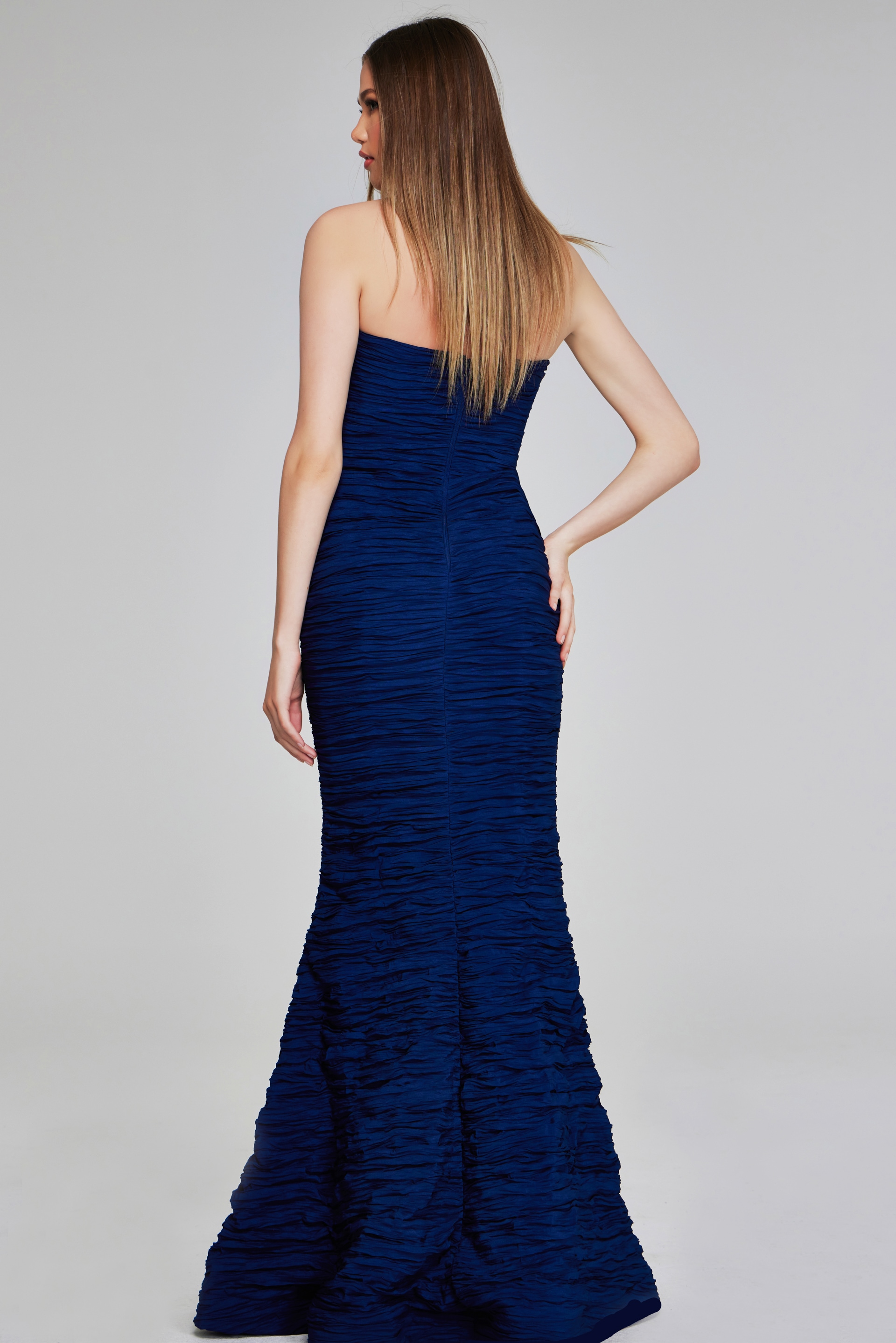 Model wearing Jovani 40045 navy mermaid gown, back view.